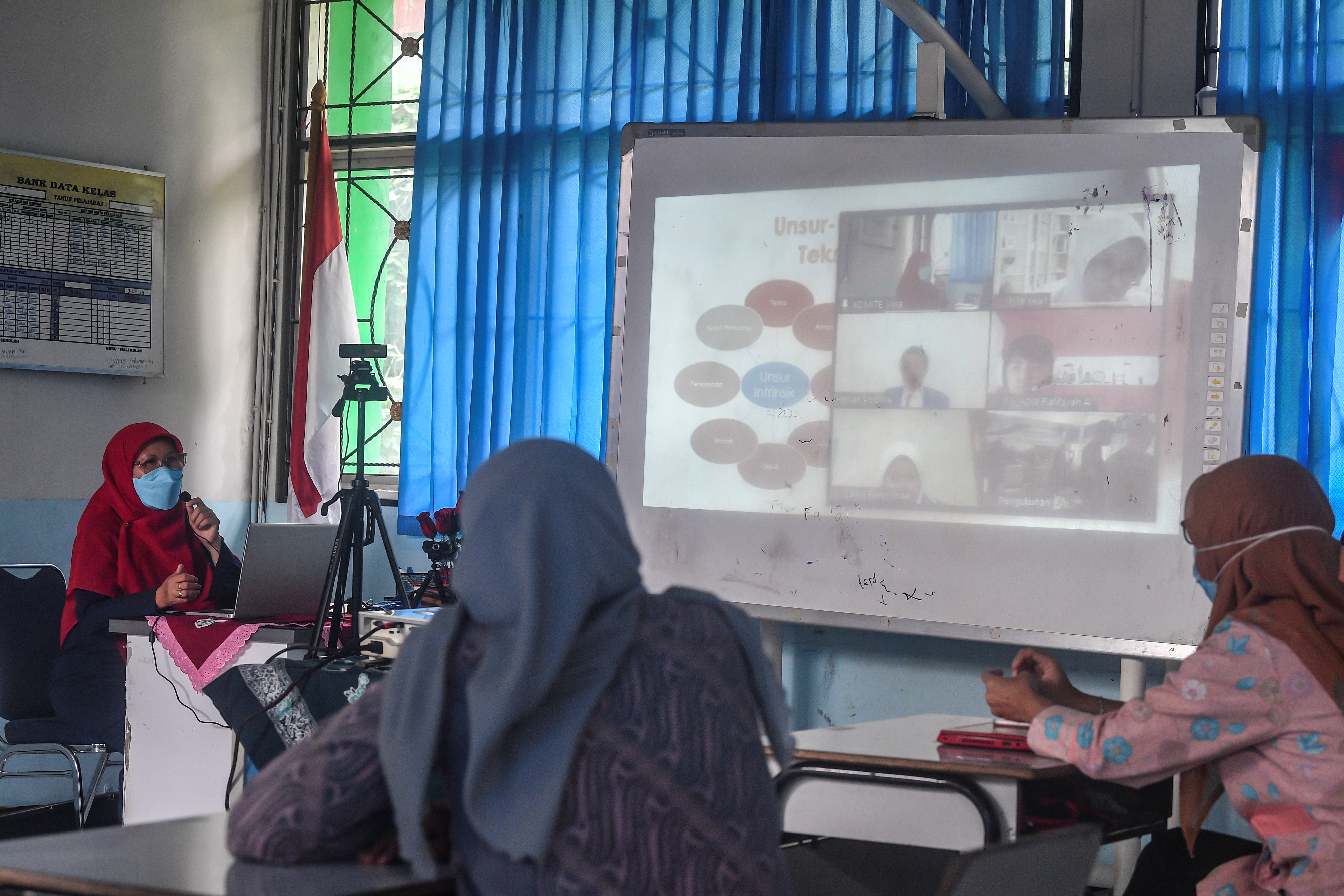 Guru beserta orangtua murid mengikuti simulasi sekolah campuran tatap muka dan daring (hybrid) di SMP 255, Jakarta Timur, Selasa (30/3).