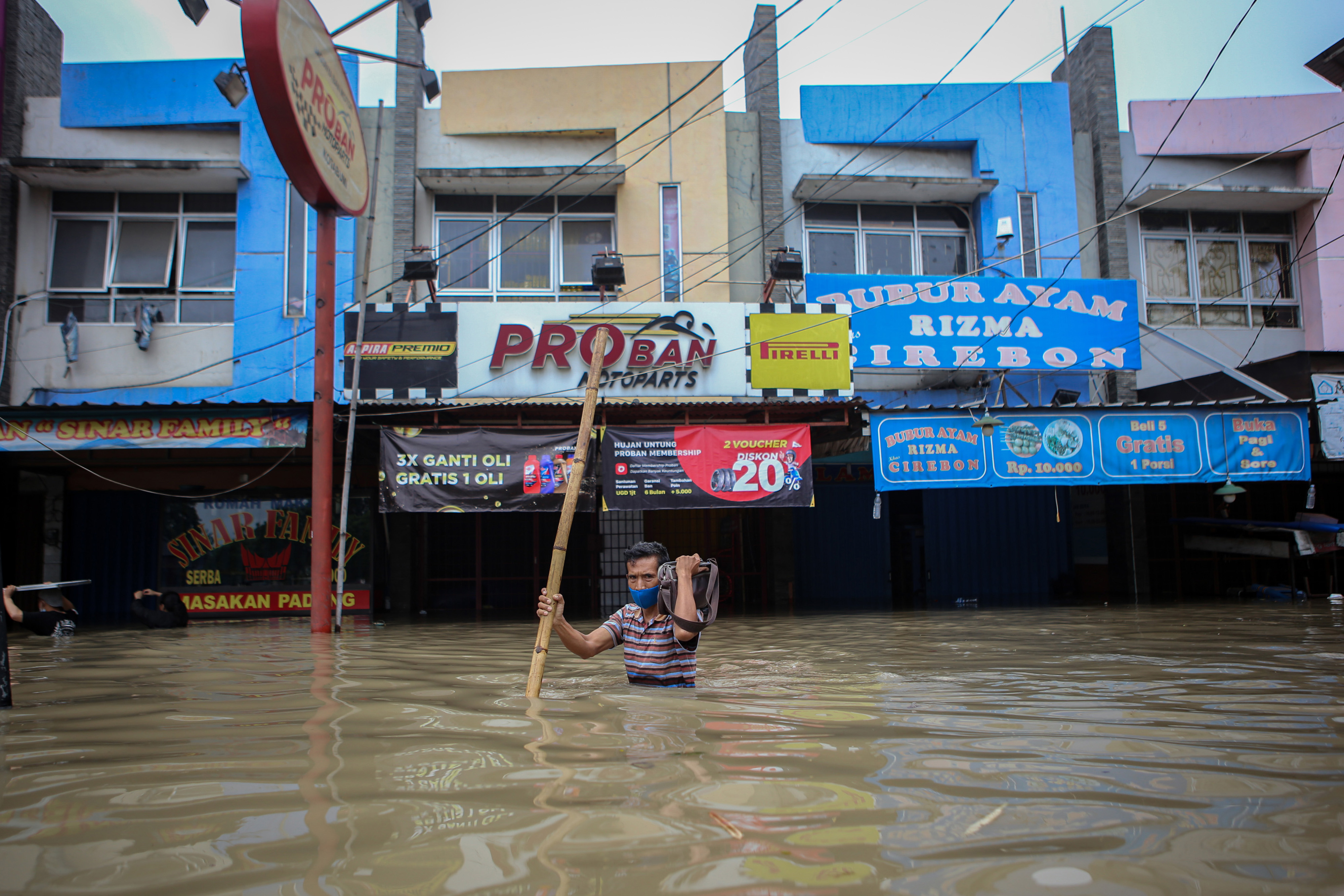 Warga berjalan menerobos banjir di kawasan Regency, Pasar Kemis, Kabupaten Tangerang, Banten, Sabtu (20/2/2021).