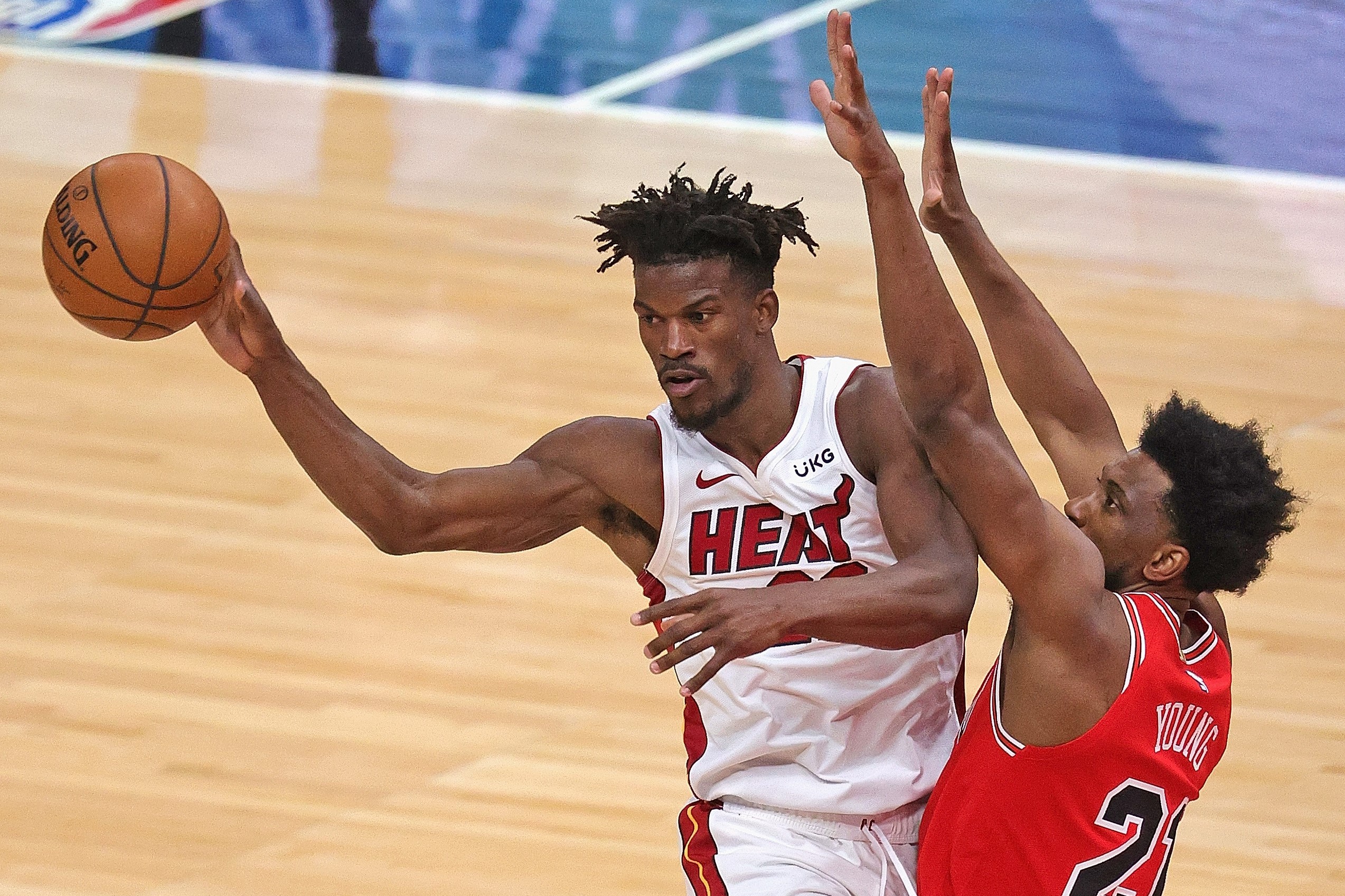 Pemain Miami Heat Jimmy Butler #22 berupaya memberikan passing melewati Pemain Chicago Bulls Thaddeus Young #21
