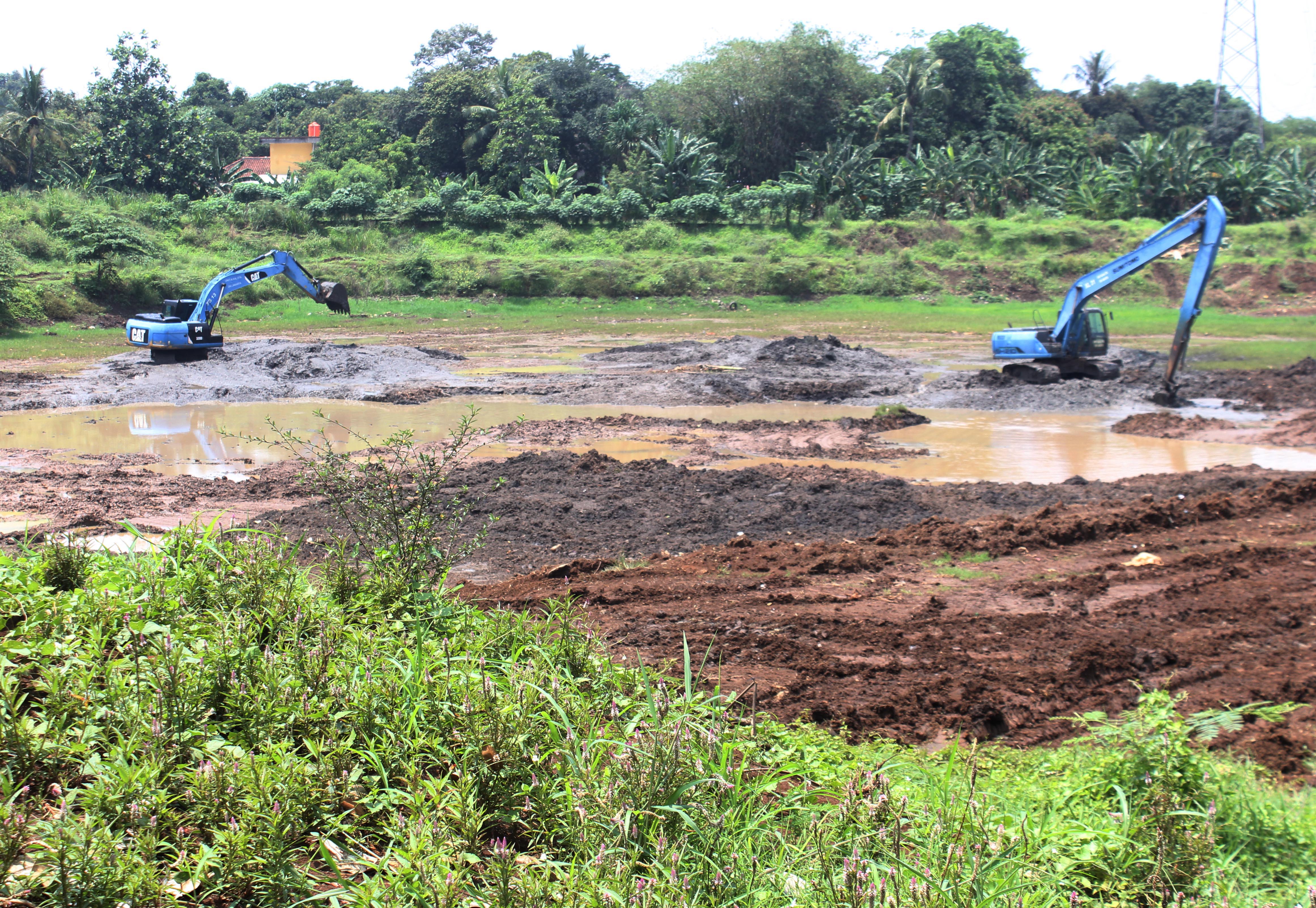 Alat berat melakukan pengalian menambah kedalaman waduk di Waduk Pondok Ranggon,  Kecamatan Cipayung, Jakarta Timur.