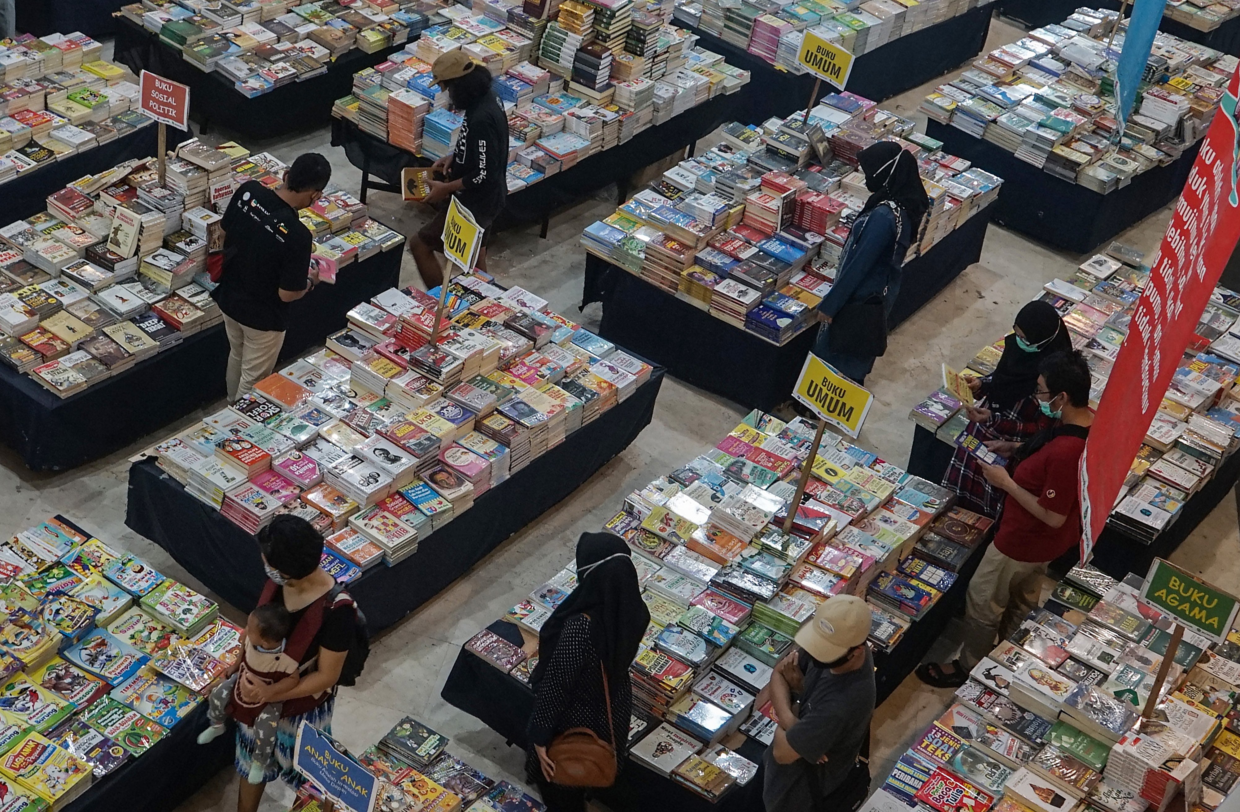 Pengunjung memiliki buku bacaan di toko buku.