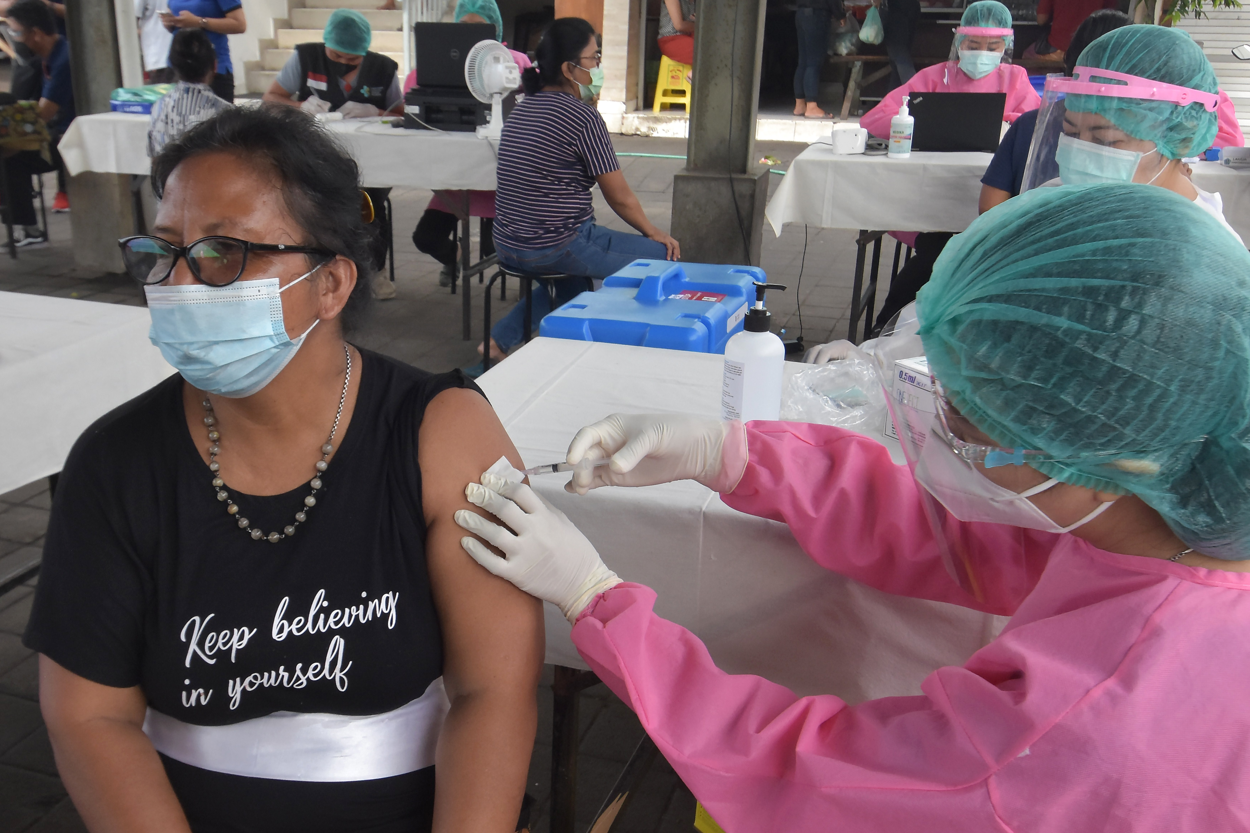 Vaksinator menyuntikkan vaksin covid-19 kepada warga saat vaksinasi massal di wilayah Sanur, Denpasar, Bali, Senin (22/3/2021). 