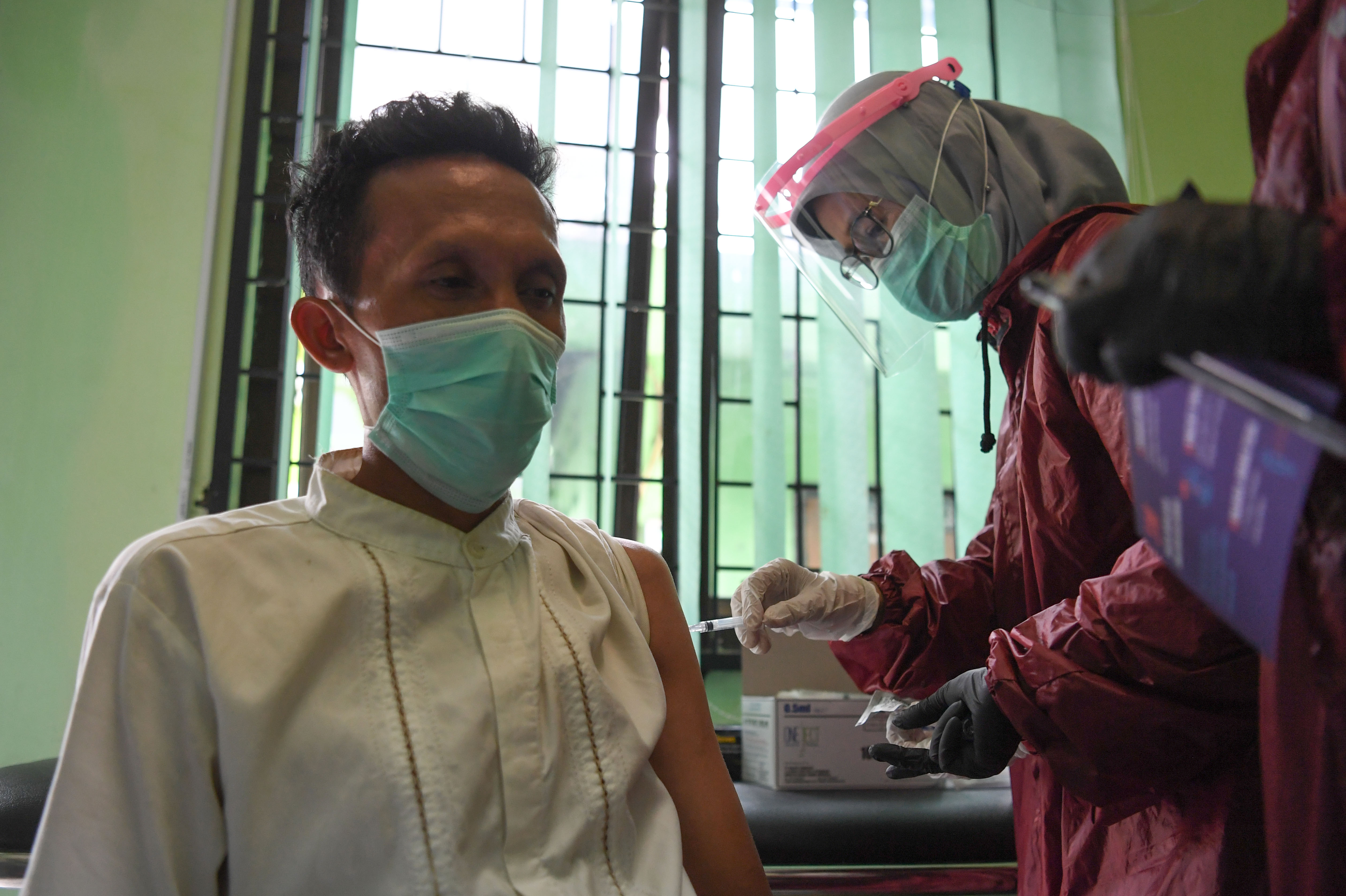  Petugas menyuntikan vaksin CoronaVac ke tenaga kesehatan di Puskesmas Tanah Baru, Depok, Jawa Barat