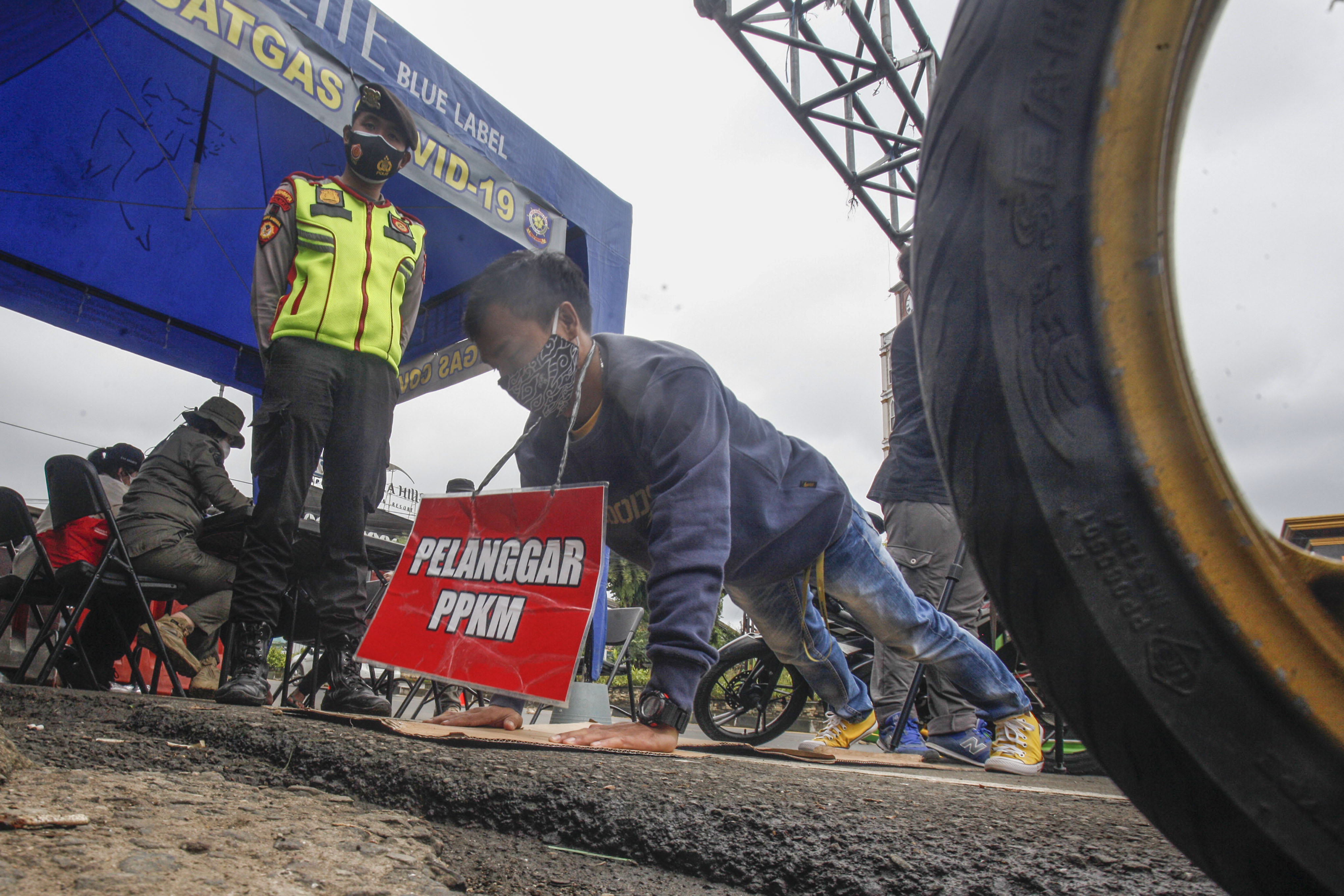 Ilustrasi petugas menindak warga yang melanggar aturan PPKM skala mikro.