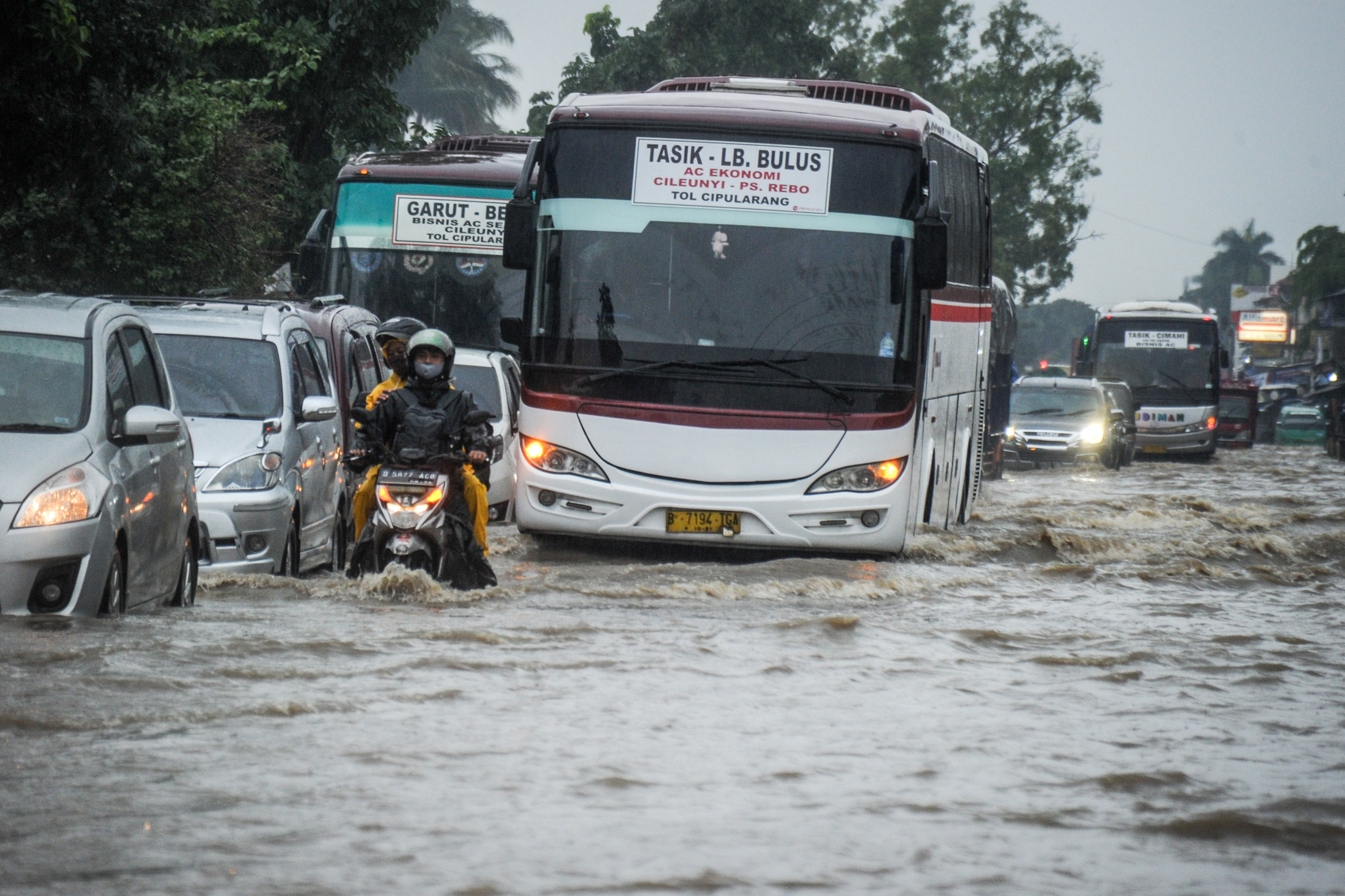 Kendaraan menerjang air menggenangi jalan nasional menuju Garut di perbatasan Kabupaten Bandung dan Sumedang, Jawa Barat, Sabtu (9/1/2021).