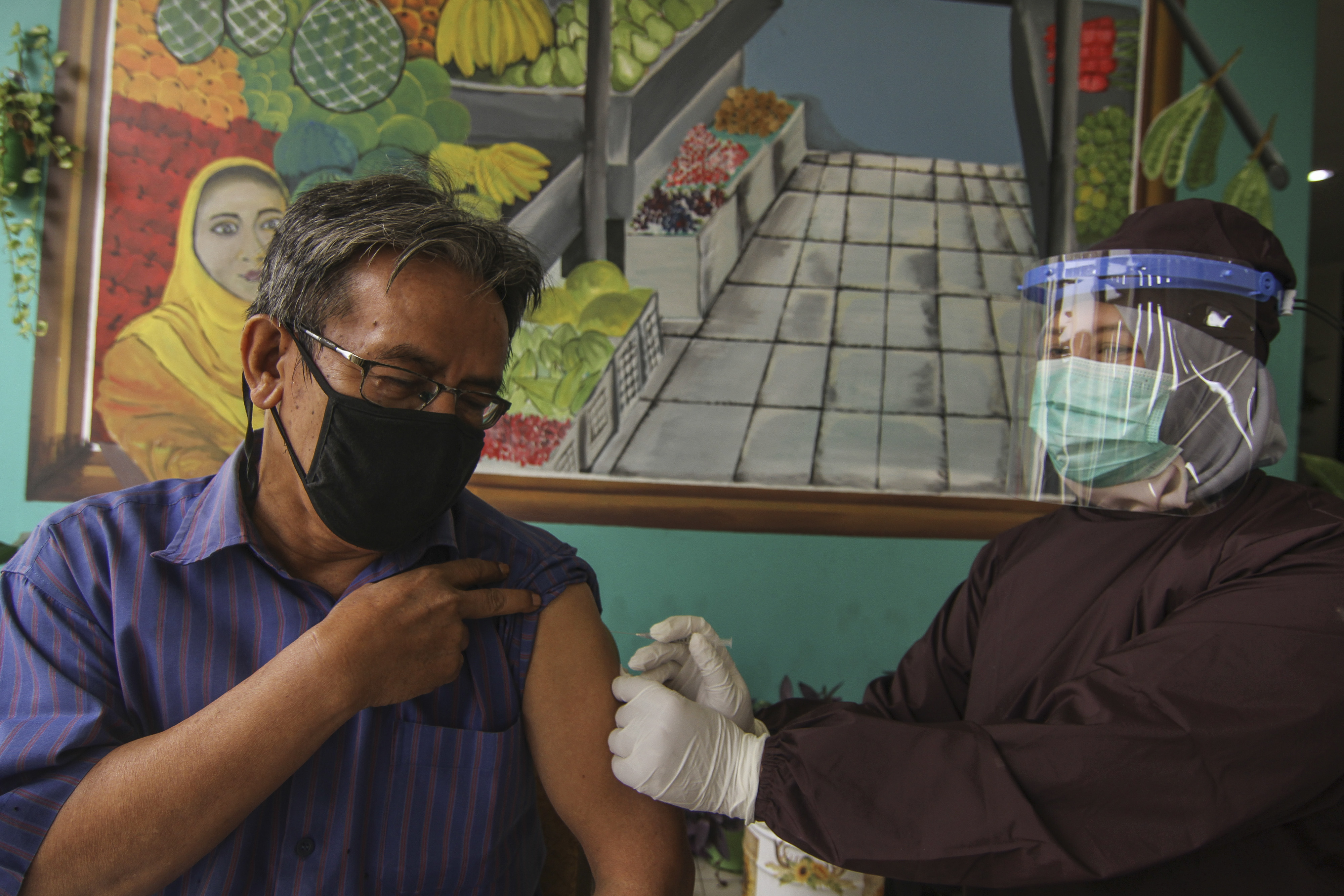  Petugas medis menyuntikan vaksin COVID-19 kepada pedagang di Pasar Cisalak, Depok, Jawa Barat, Selasa (9/3/2021).