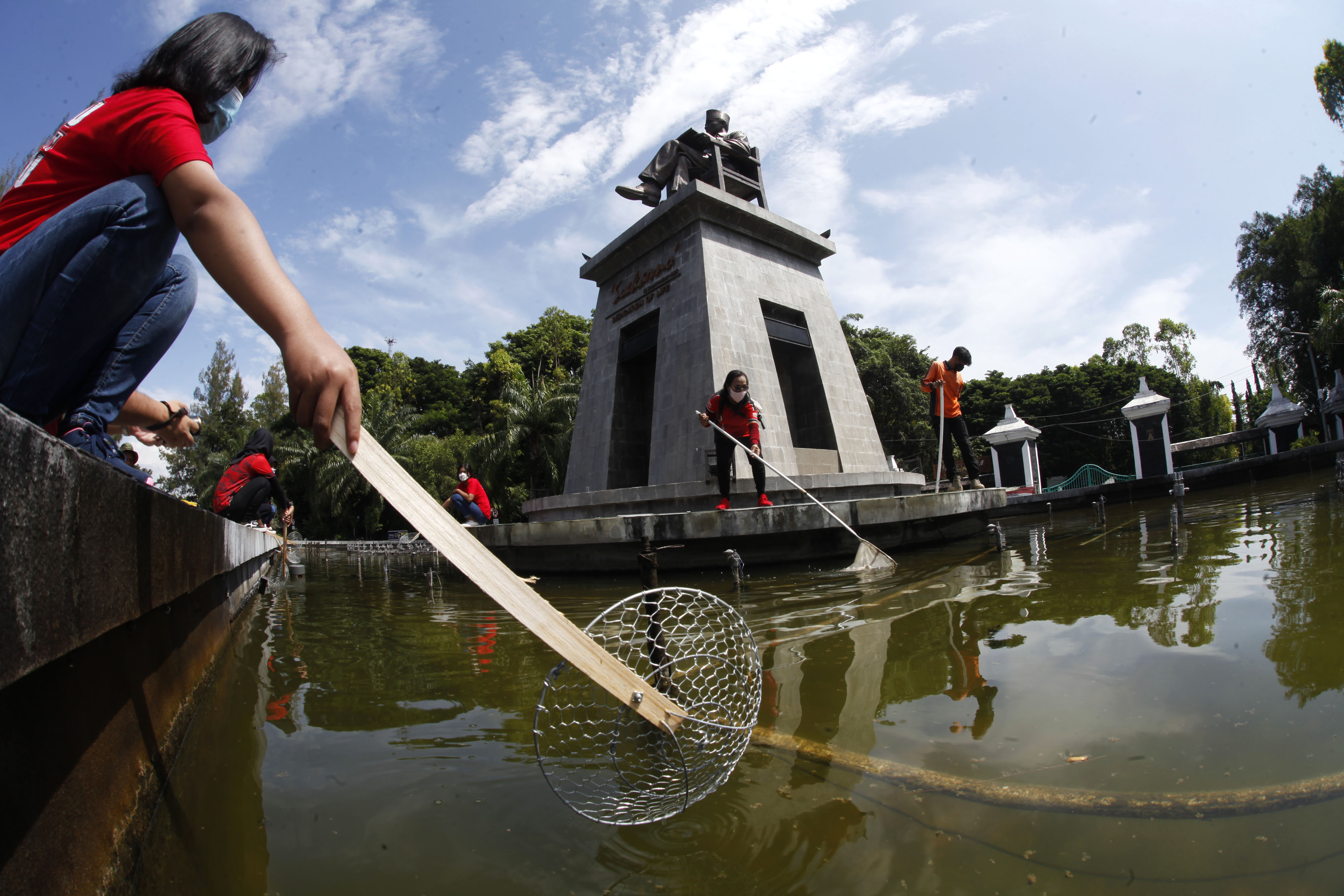 Anggota Srikandi Pasoepati membersihkan air mancur di kawasan Stadion Manahan, Solo, Jawa Tengah, Senin (22/3/2021).
