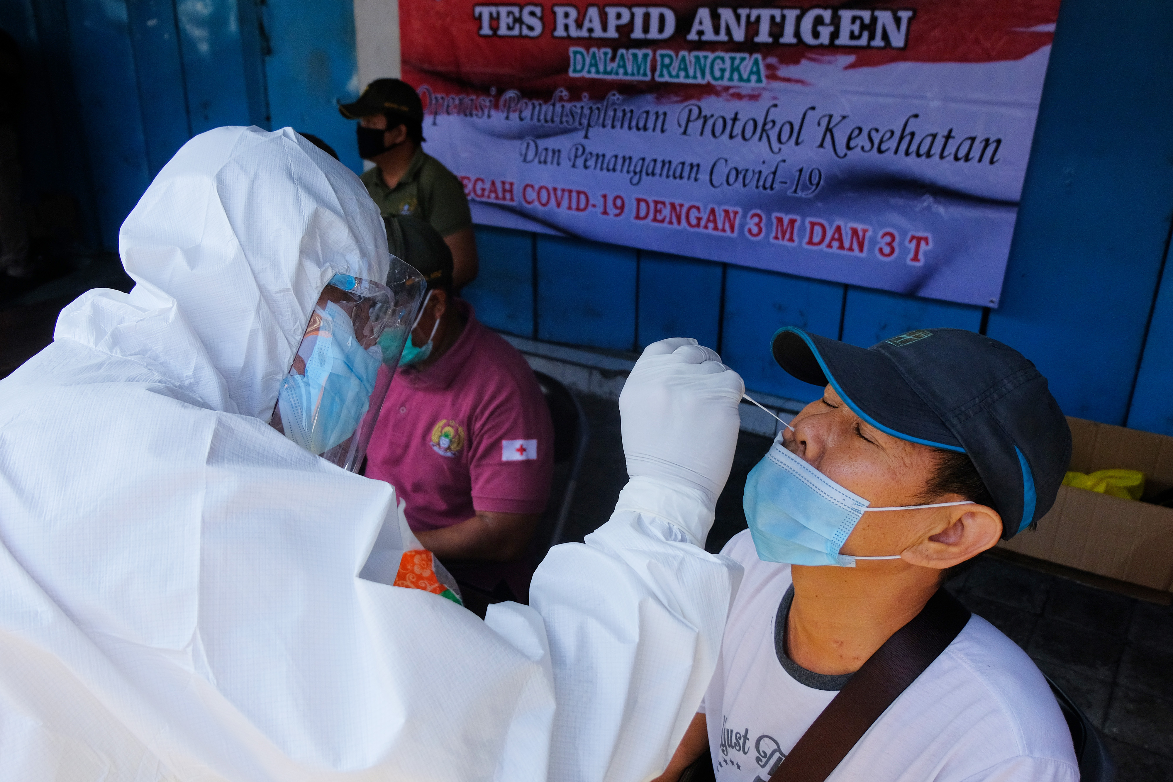 Petugas kesehatan melakukan tes cepat antigen bagi warga di Denpasar, Bali.