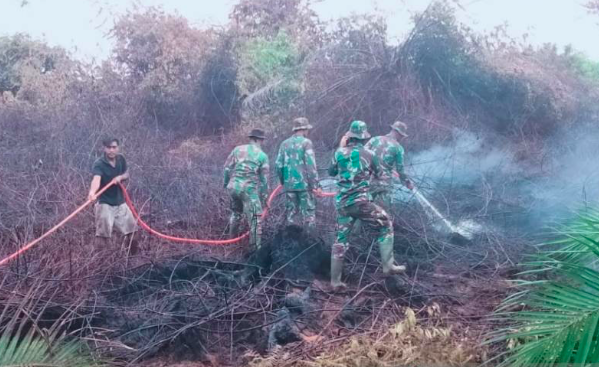 Prajurit TNI bersama masyarakat dan petugas BPBD masih berupaya memadamnkan api di lokasi kebakaran lahan gambut di kawasan Desa Puloe Ie.
