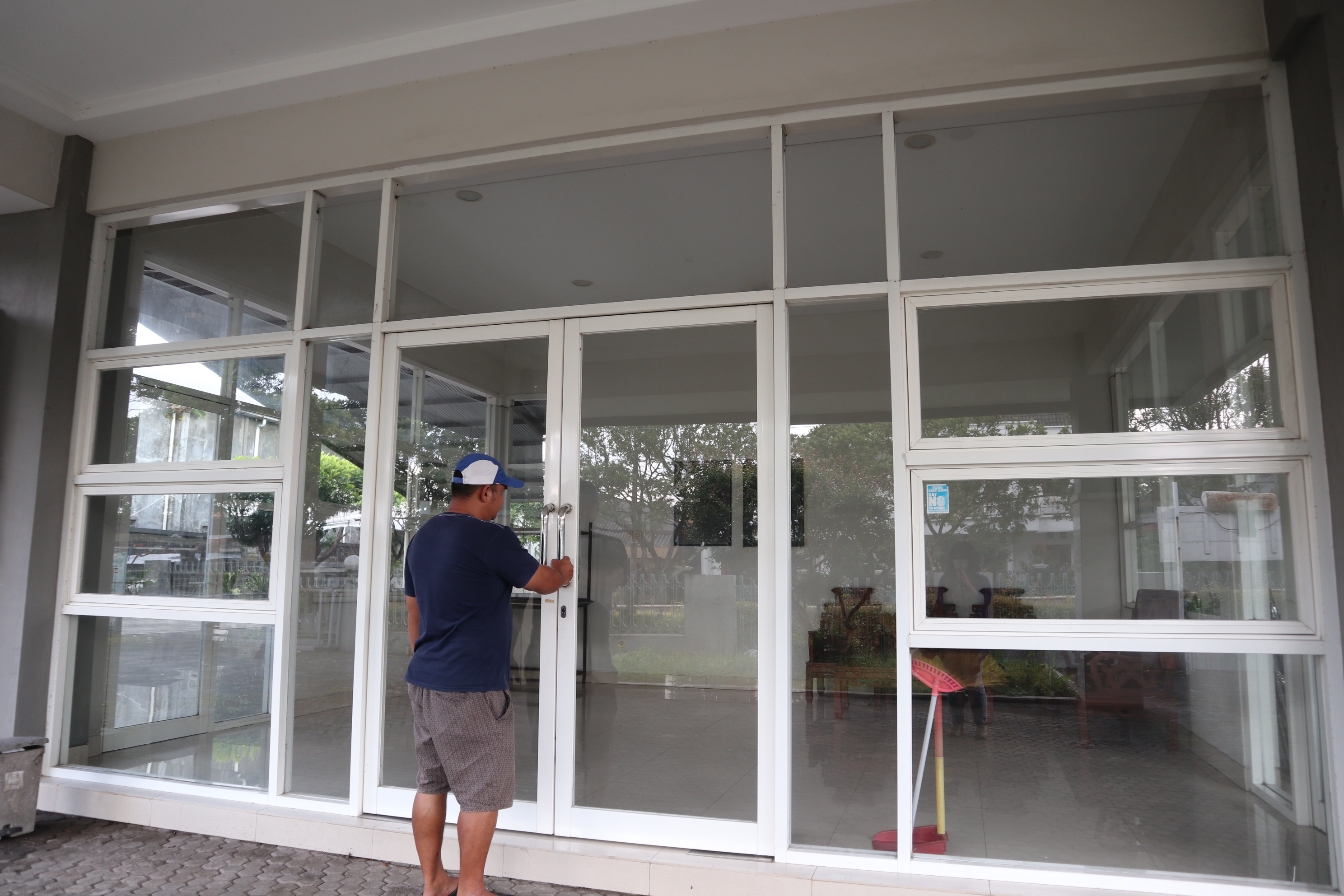 Petugas perawat jenazah Timotiyus Budi Rahman, 38, menutup pintu rumah duka Dono Praloyo Temanggung, Senin (1/3/2021). 