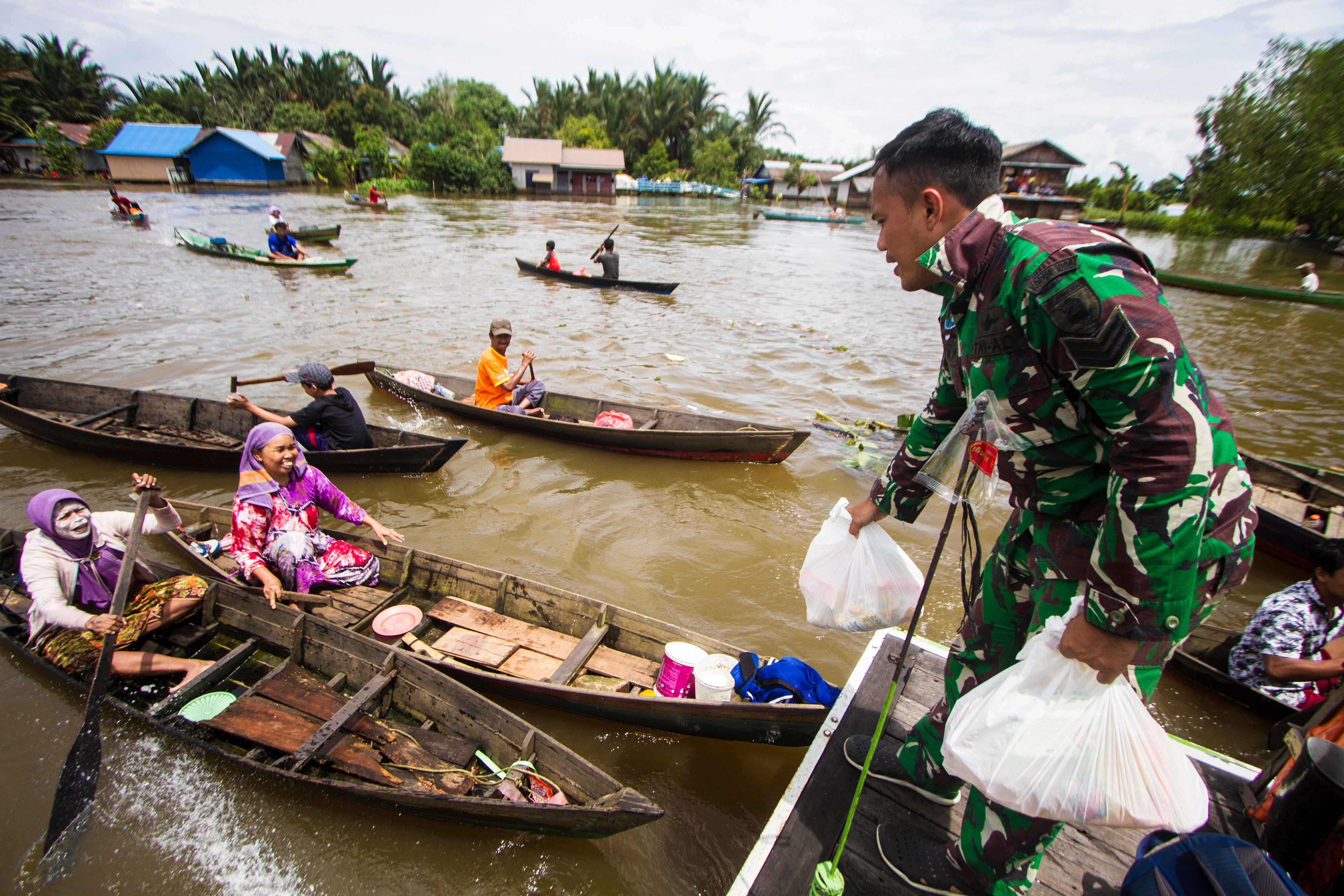 Anggota TNI AD memberikan bantuan sembako kepada warga yang terdampak banjir di Kabupaten Banjar, Kalimantan Selatan, Selasa (26/1/2021).