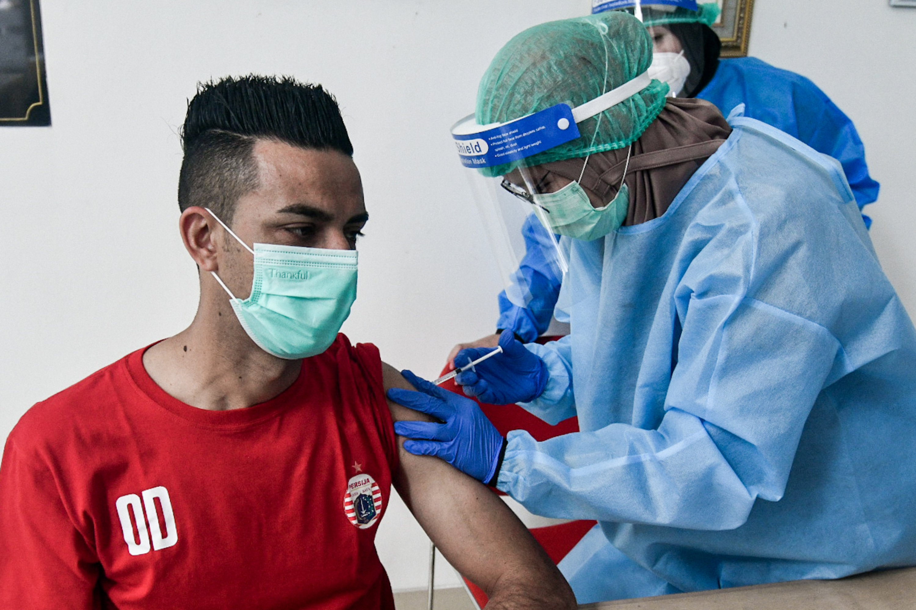 Pemain Persija Jakarta Otavio Dutra menjalani vaksinasi covid-19 dosis kedua di RSON, Jakarta, Jumat (12/3).