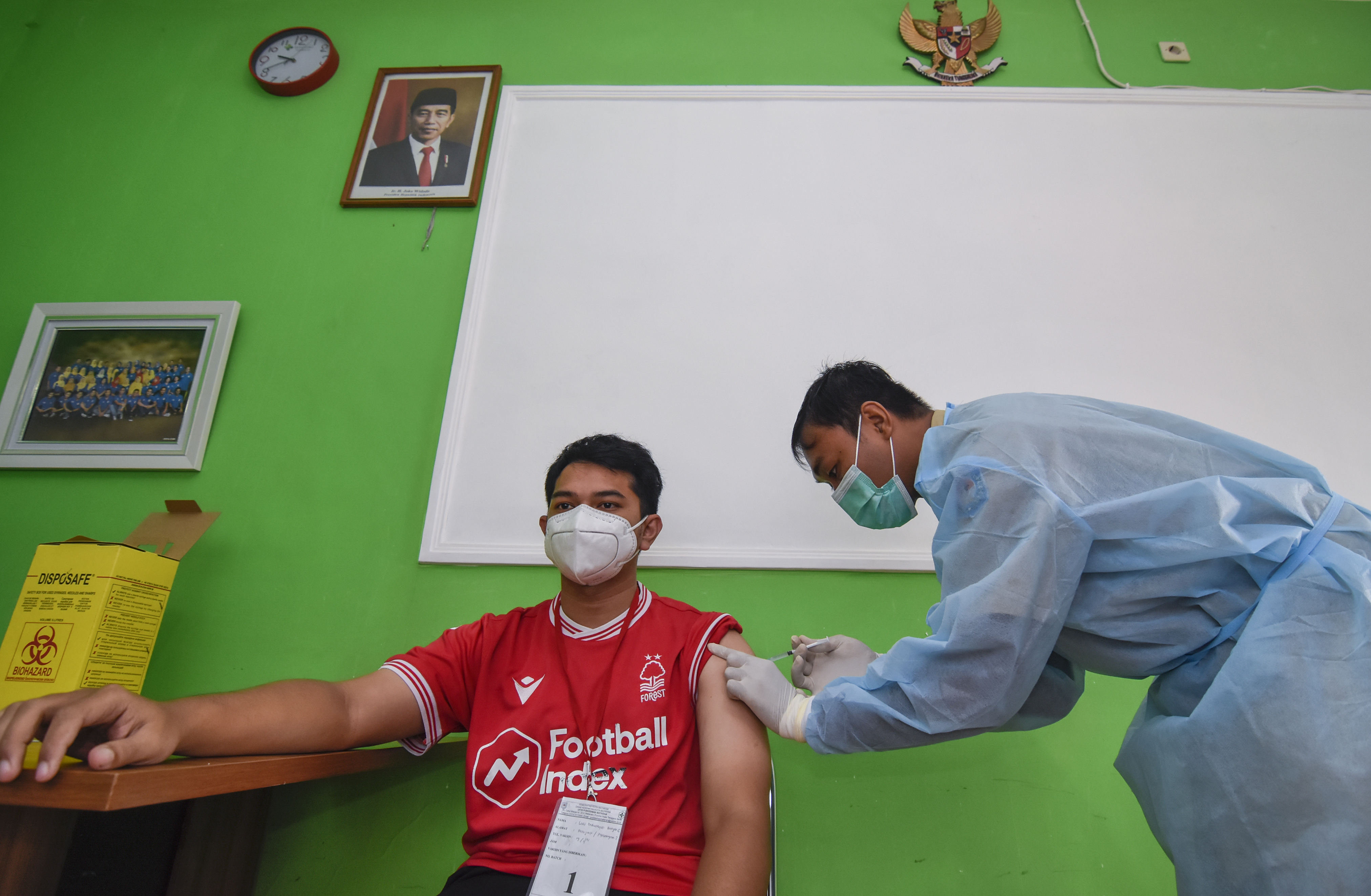 Seorang tenaga kesehatan di Nusa Tenggara Barat sedang memvaksinasi warga.