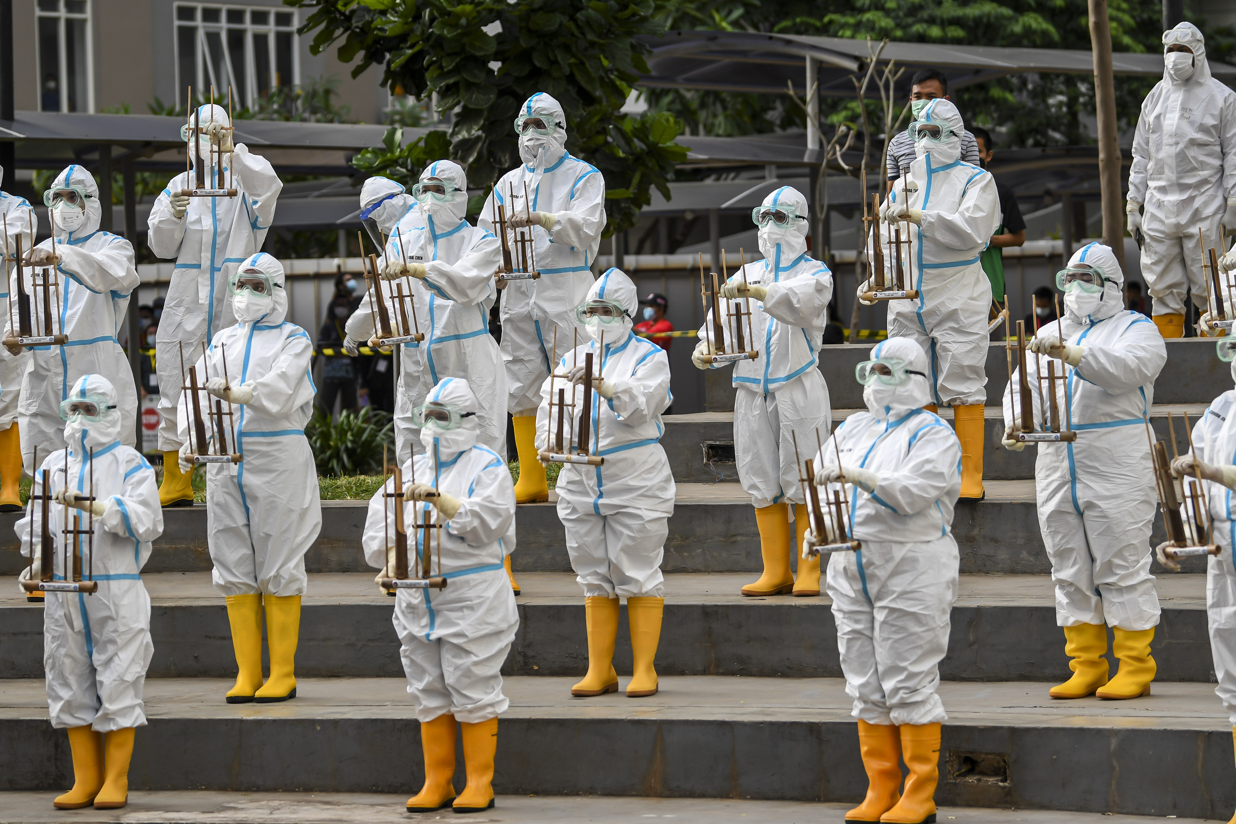 Tenaga kesehatan memainkan angklung saat merayakan satu tahun Rumah Sakit Darurat Covid-19 Wisma Atlet Kemayoran, Jakarta