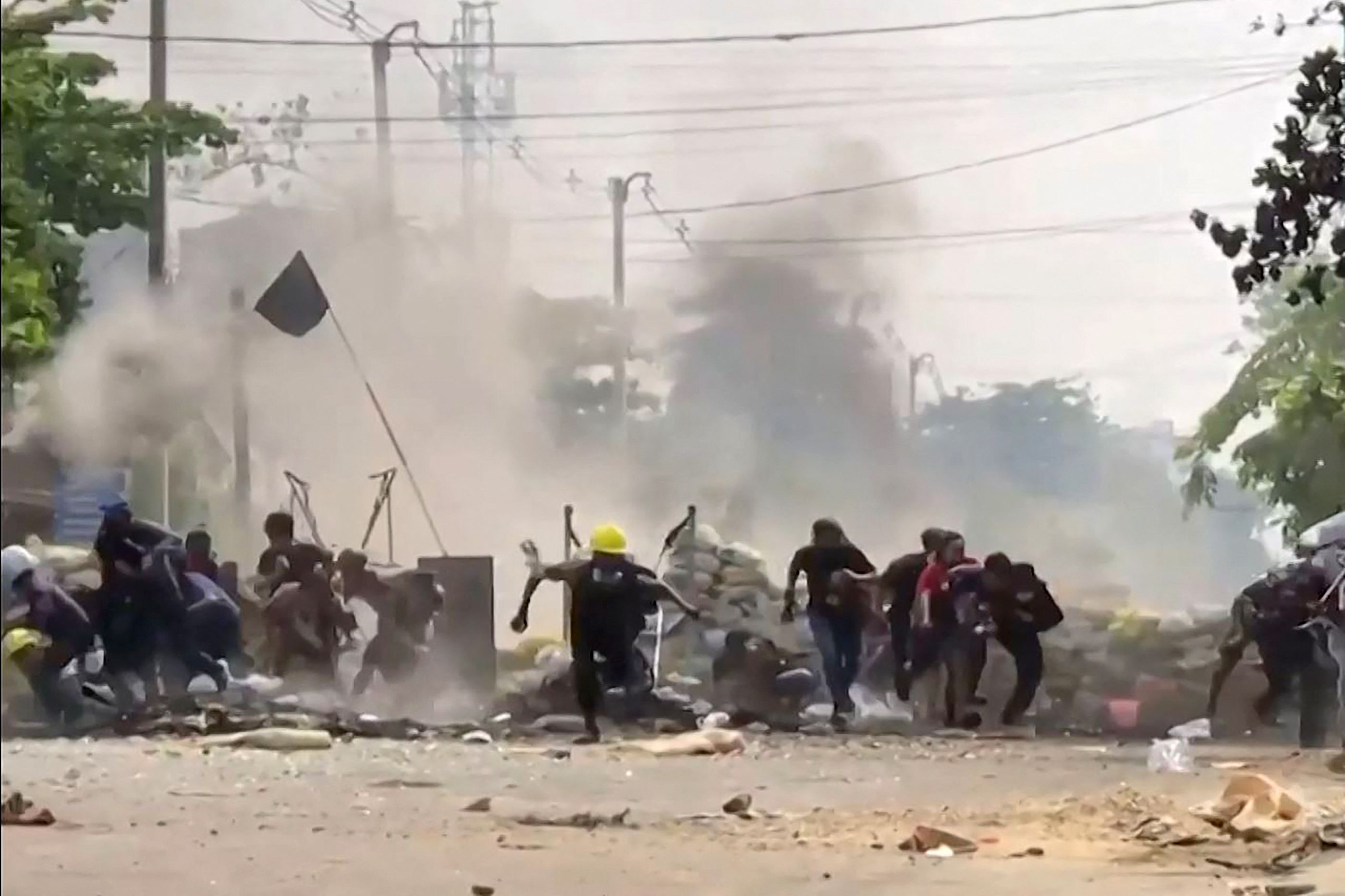 Demonstran berhamburan setelah barikade mereka diledakkan militer di Yangon, Myanmar.