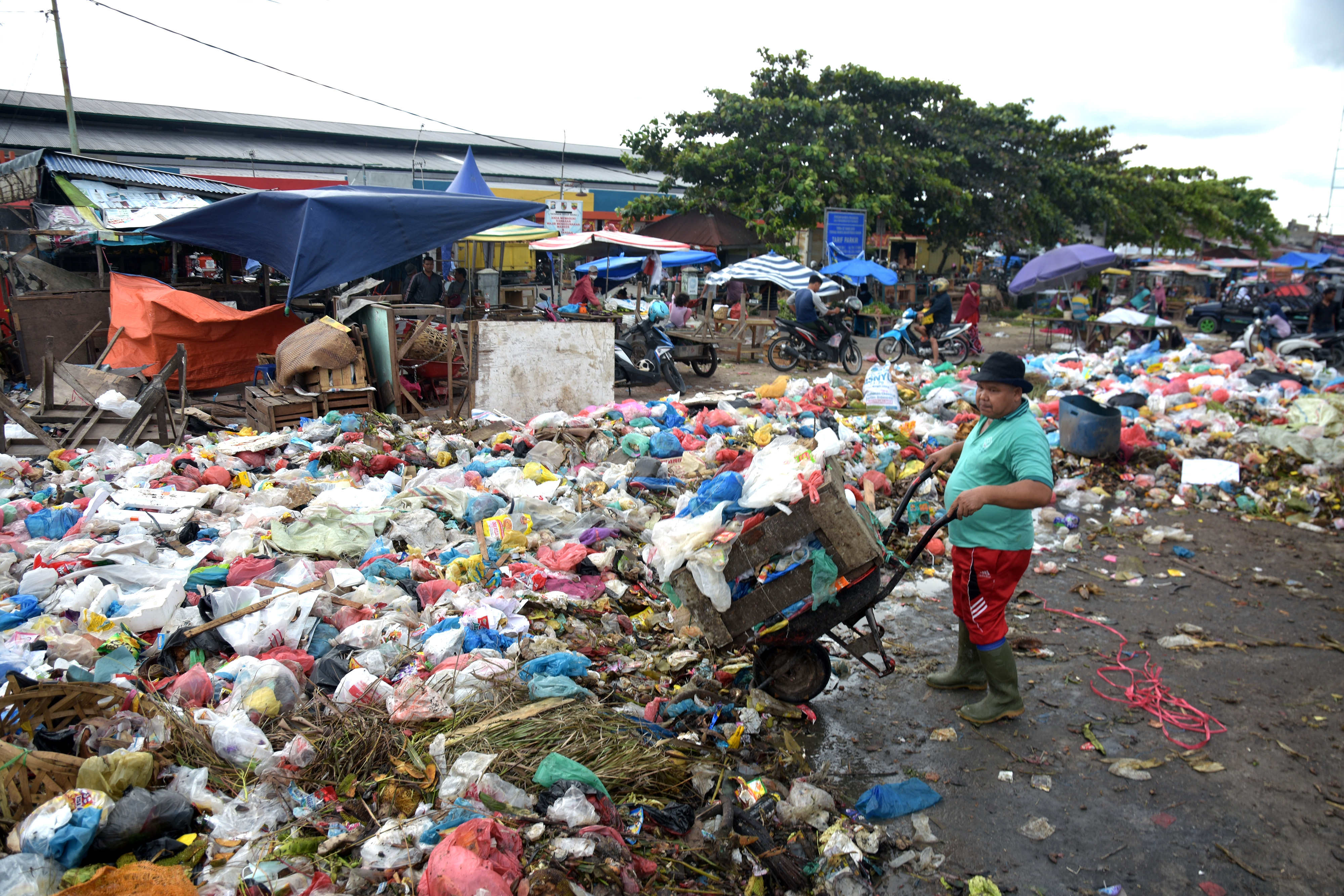  Seorang pedagang membuang sampah di depan Pasar Pagi Arengka di Kota Pekanbaru, Riau. 