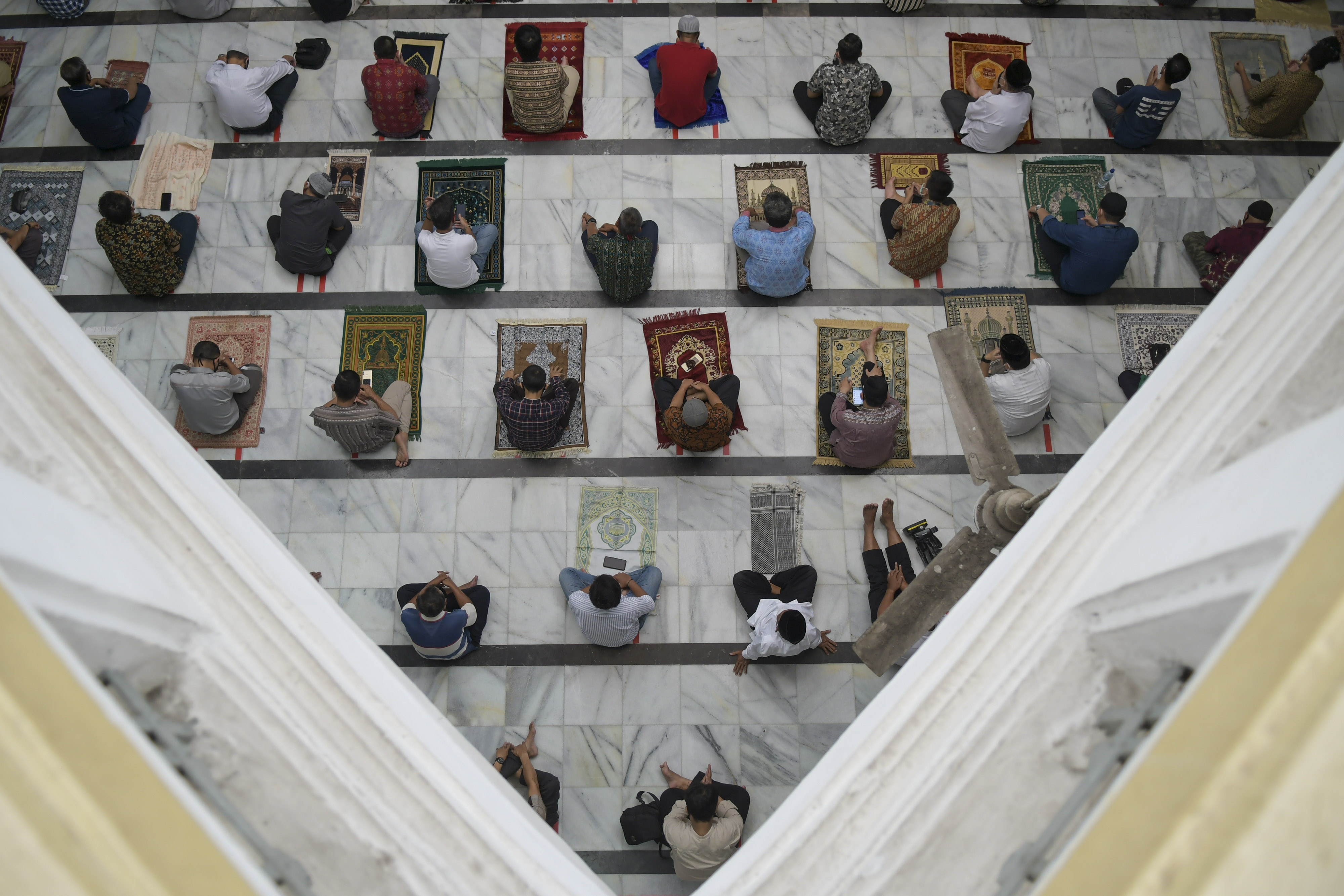 Protokol kesehatan pencegahan covid-19 di masjid diterapkan dengan memakai masker dan menjaga jarak.