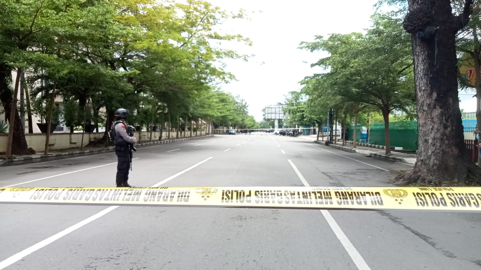 Petugas memberi garis polisi paska ledakan bom di depan gereja Katedral