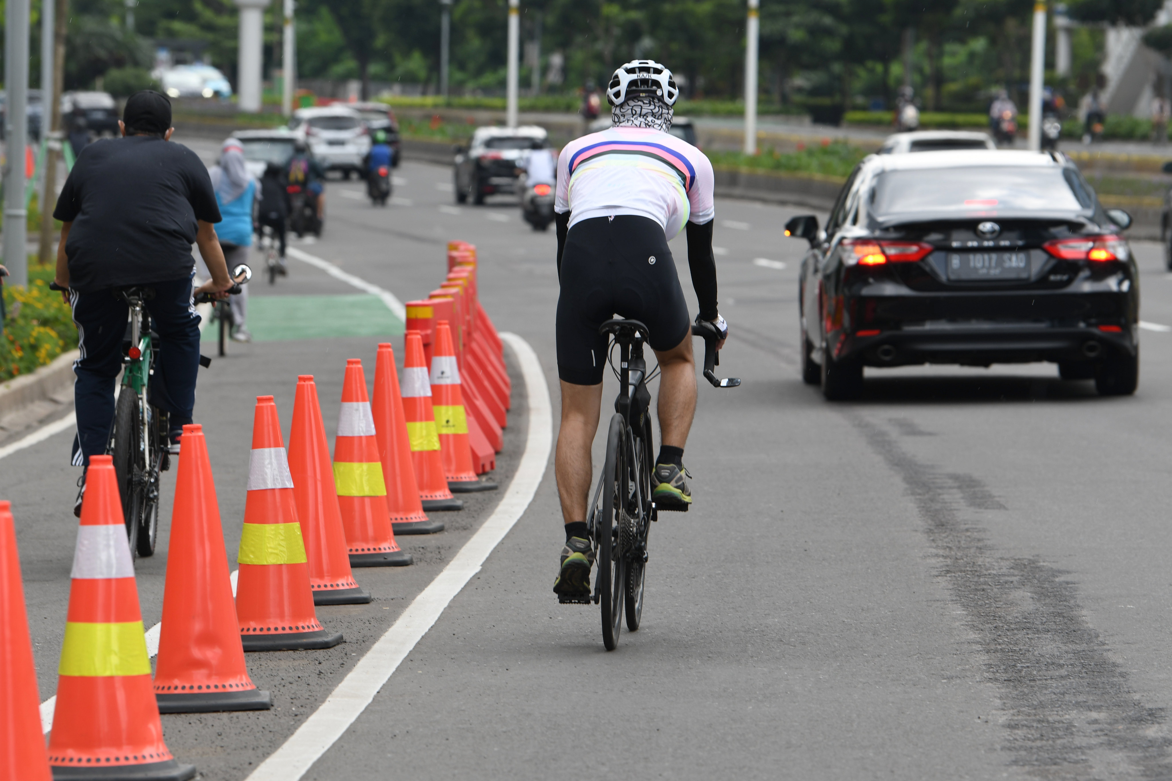 Pesepeda melintas di luar jalur sepeda di Jalan Jenderal Sudirman di Jakarta, Minggu (14/3/2021).