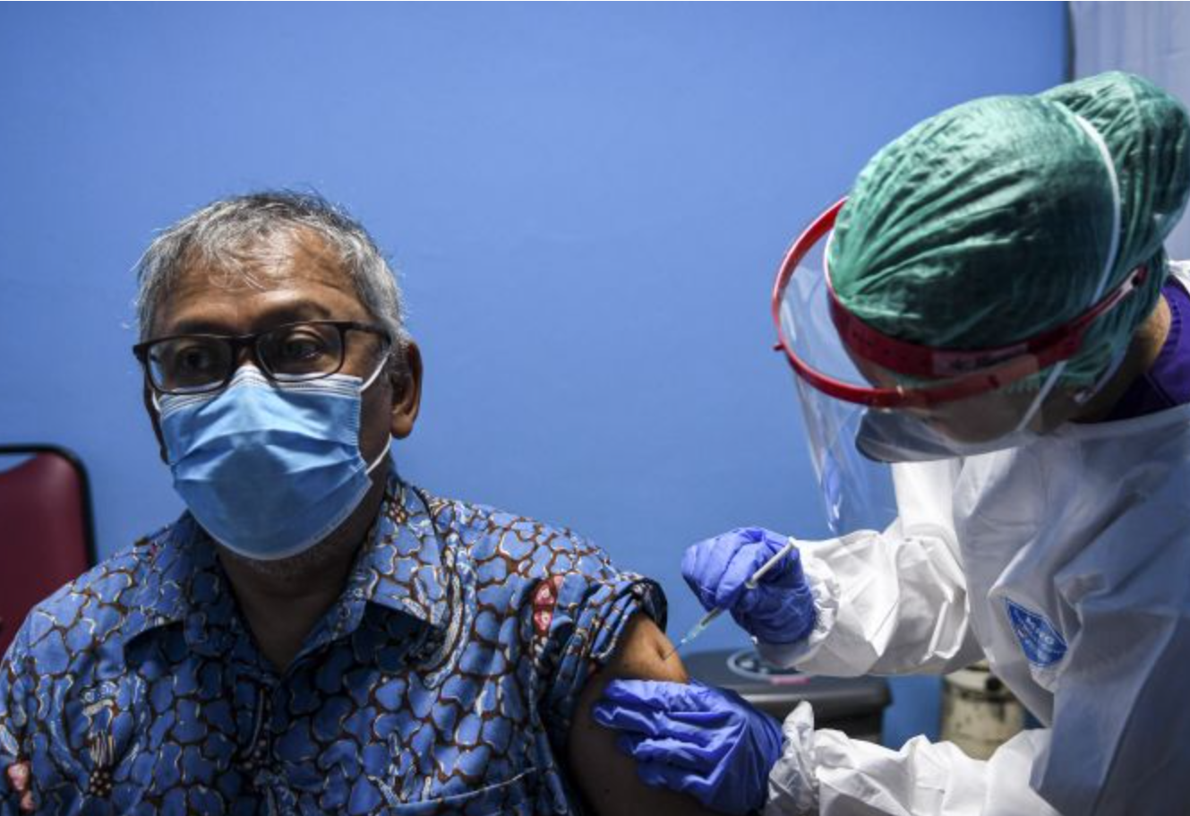 Petugas kesehatan menyuntikkan vaksin covid-19 kepada warga lansia.