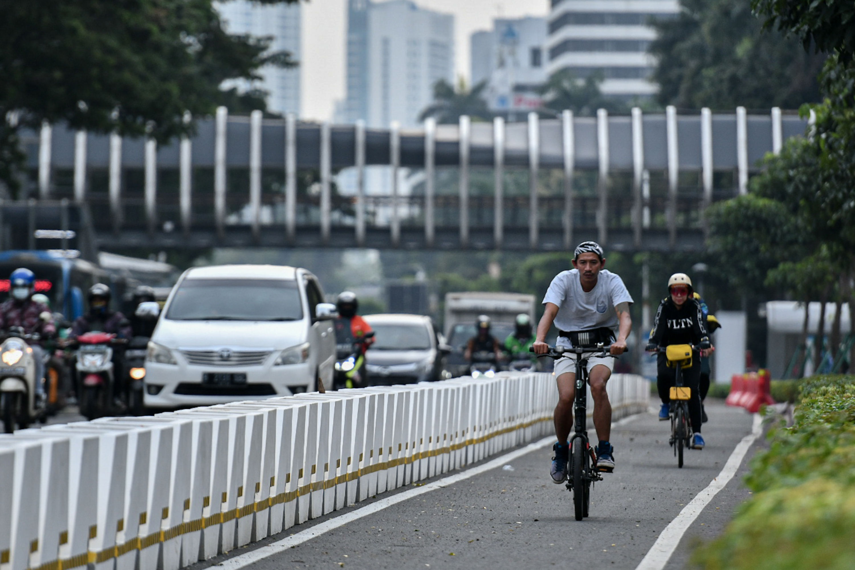 Pengendara sepeda melintasi jalur khusus di kawasan Sudirman-Thamrin, Jakarta.  