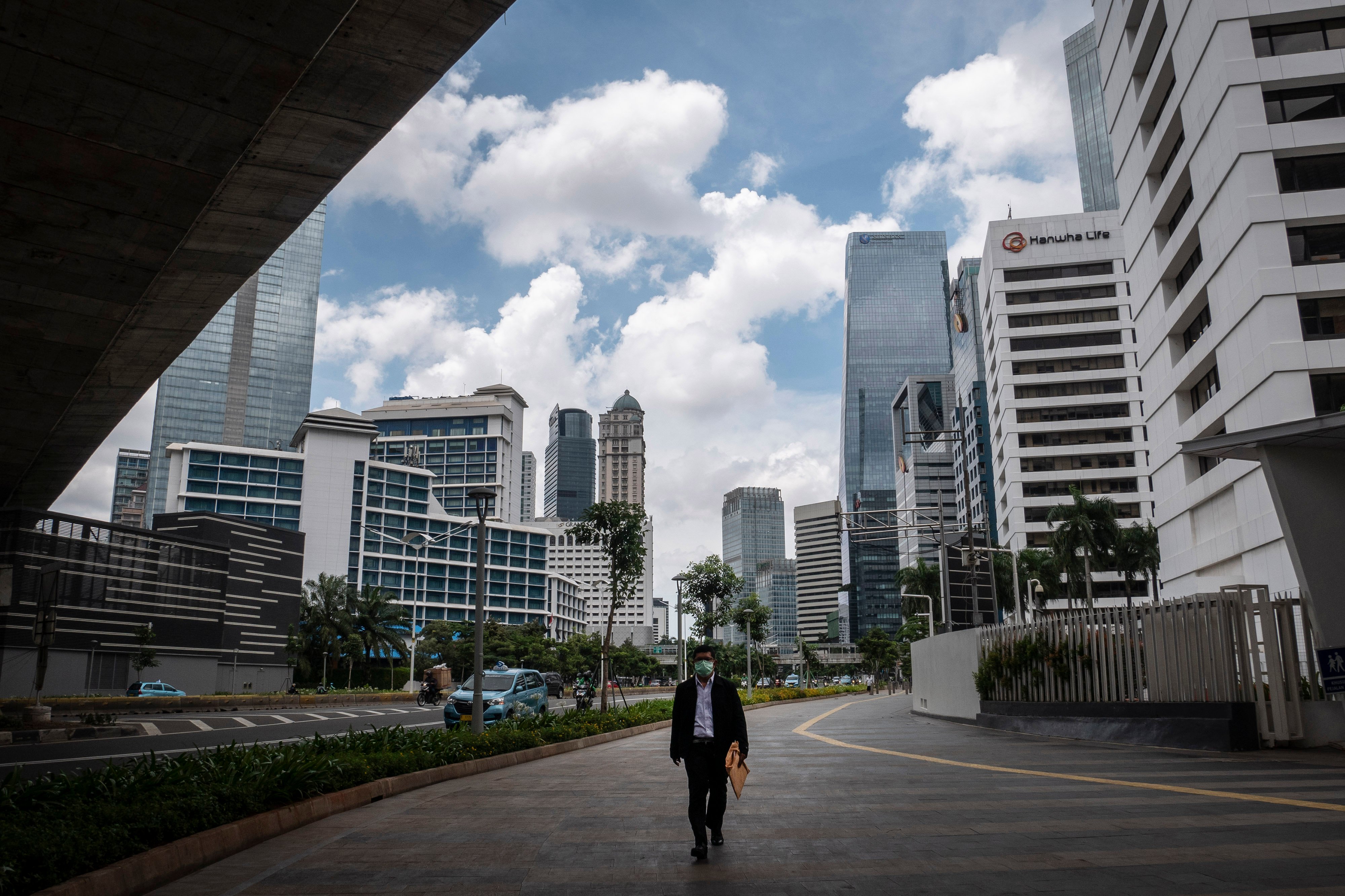 pekerja berjalan di kawasan Jalan Jenderal Sudirman, Jakarta