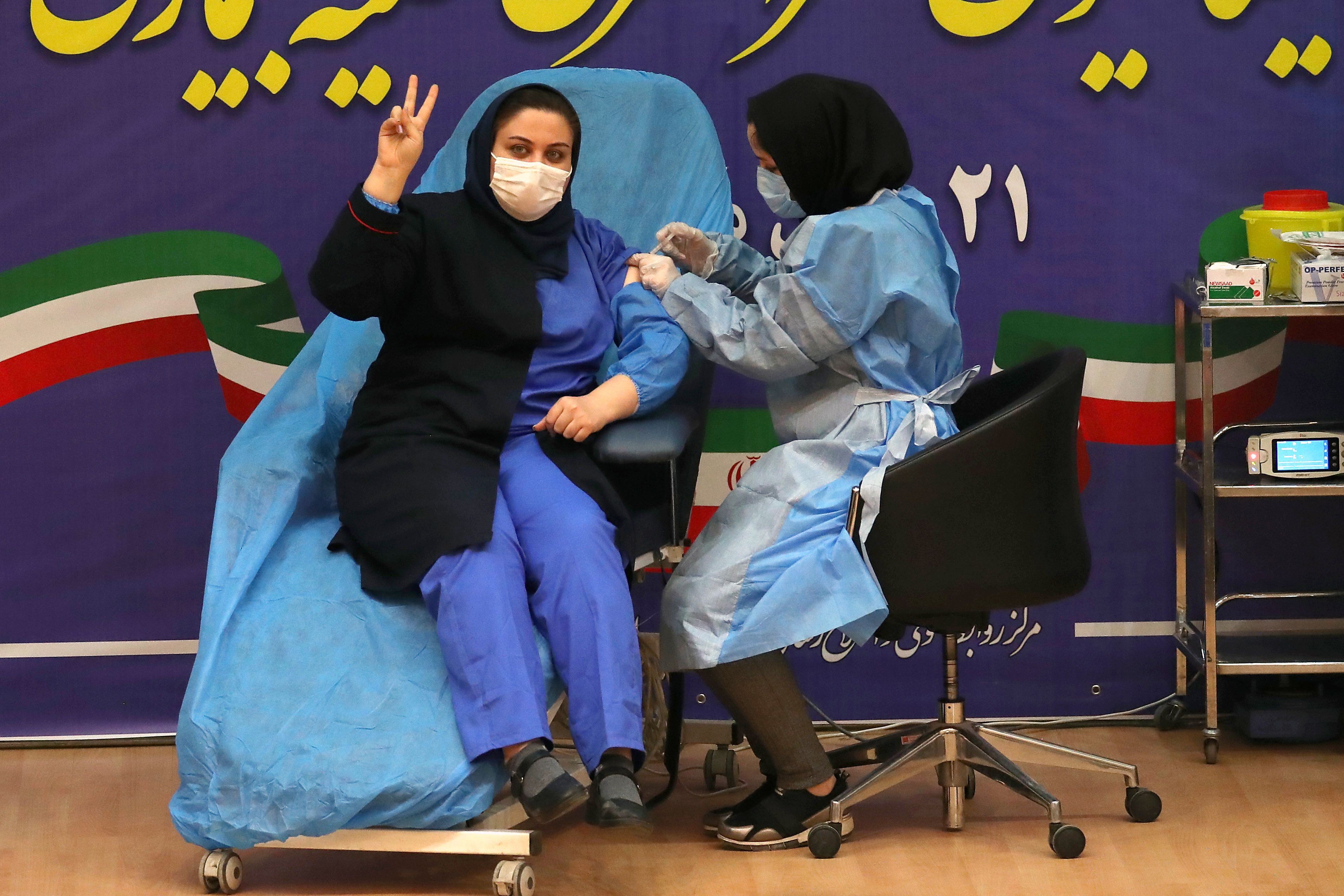 Petugas kesehatan Iran Sara Gudarzi menerima vaksin covid-19 ketika negara itu meluncurkan kampanye inokulasinya.