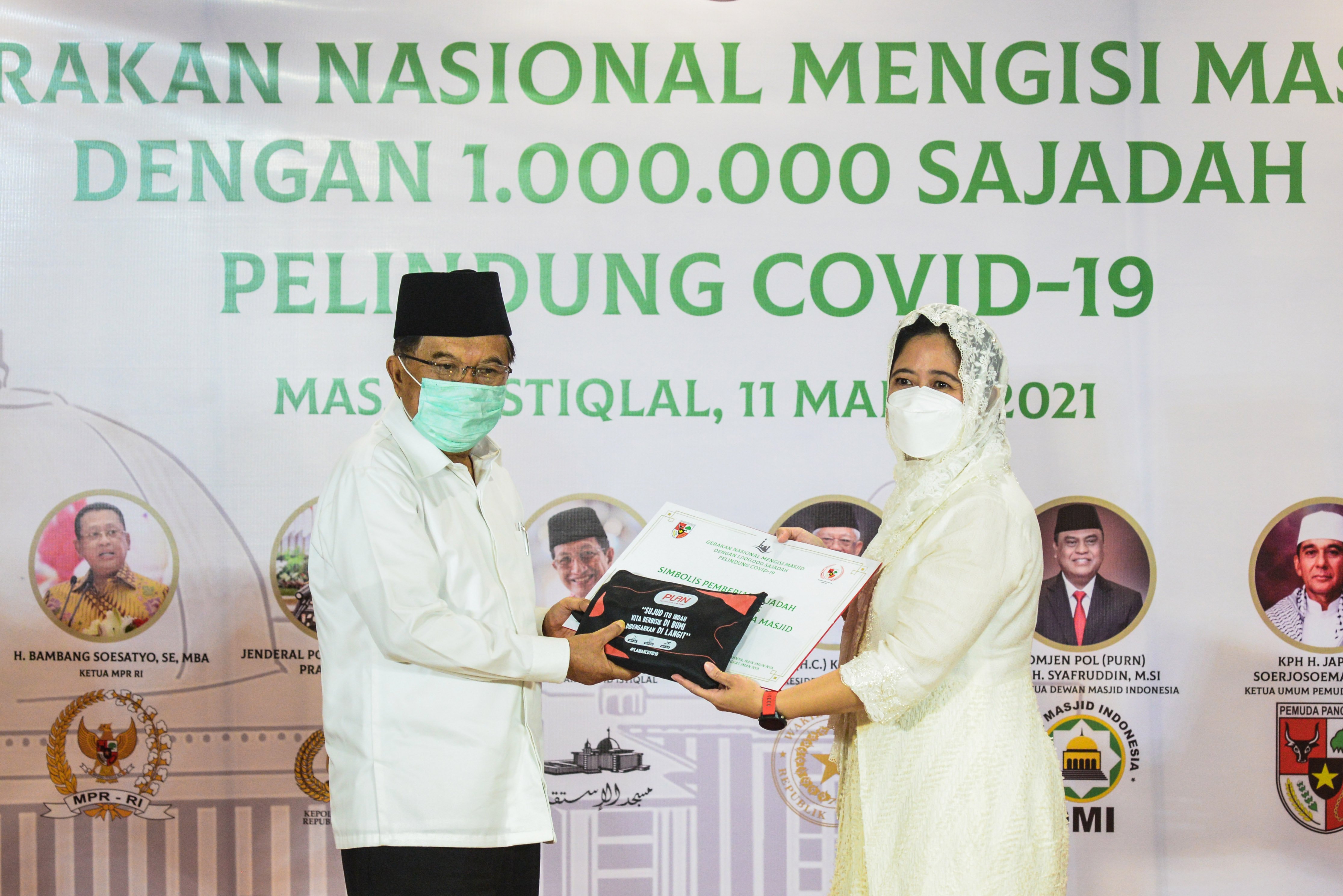 Ketua Dewan Masjid Indonesia Jusuf Kalla (kiri) dan Ketua DPR RI Puan Maharani dalam serah terima sajadah pelindung covid-19, Kamis (11/3). 