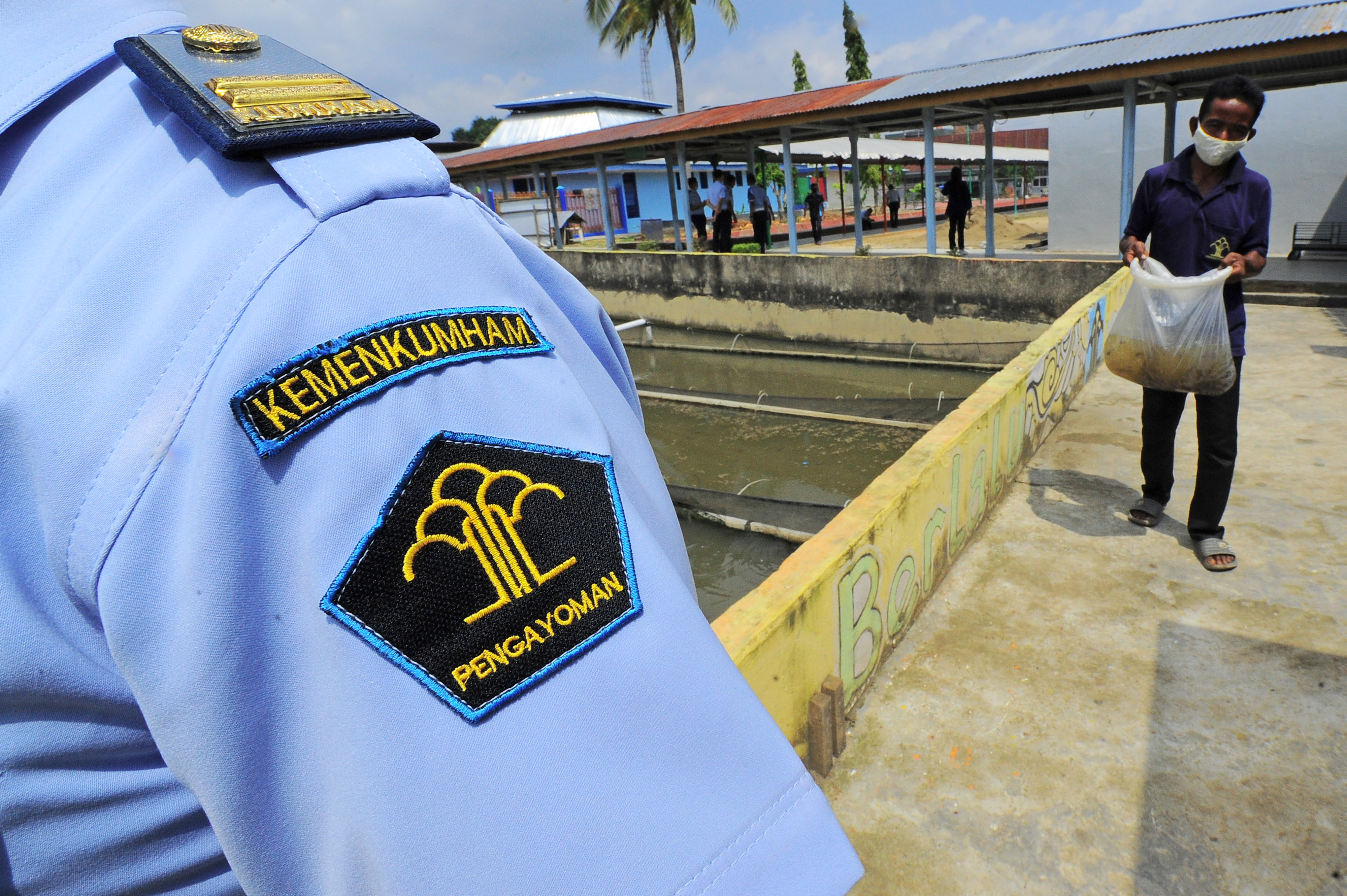 Petugas mendampingi warga binaan mengangkat bibit lele sebelum dipindahkan ke kolam pelatihan Lapas Kelas II A Jambi, Selasa (16/2/2021).