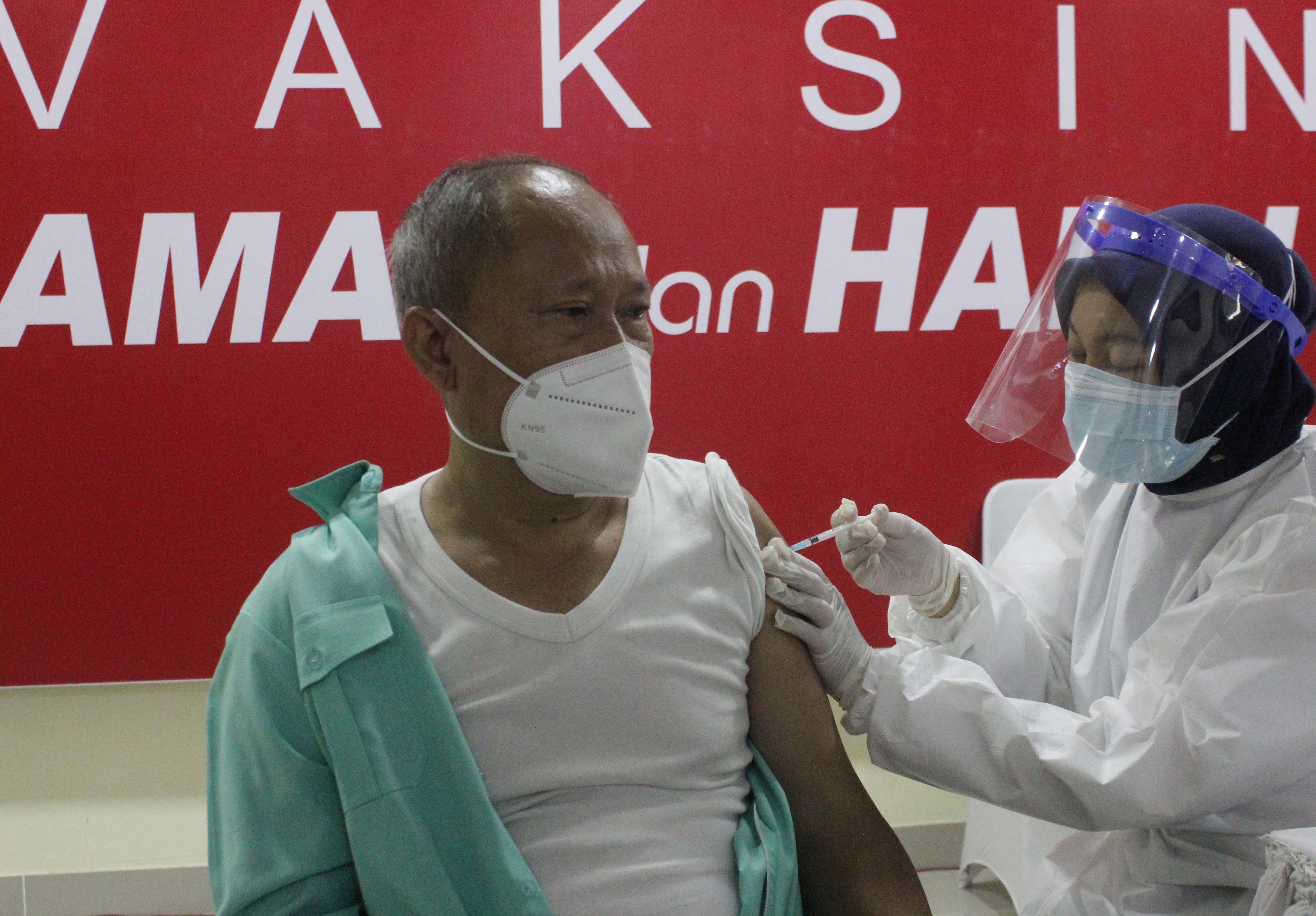 Vaksinator menyuntikkan vaksin covid-19 Sinovac  tahap I kepada guru yang dipusatkan di SMAN 70 Jakarta Selatan, Rabu (24/2/2021).