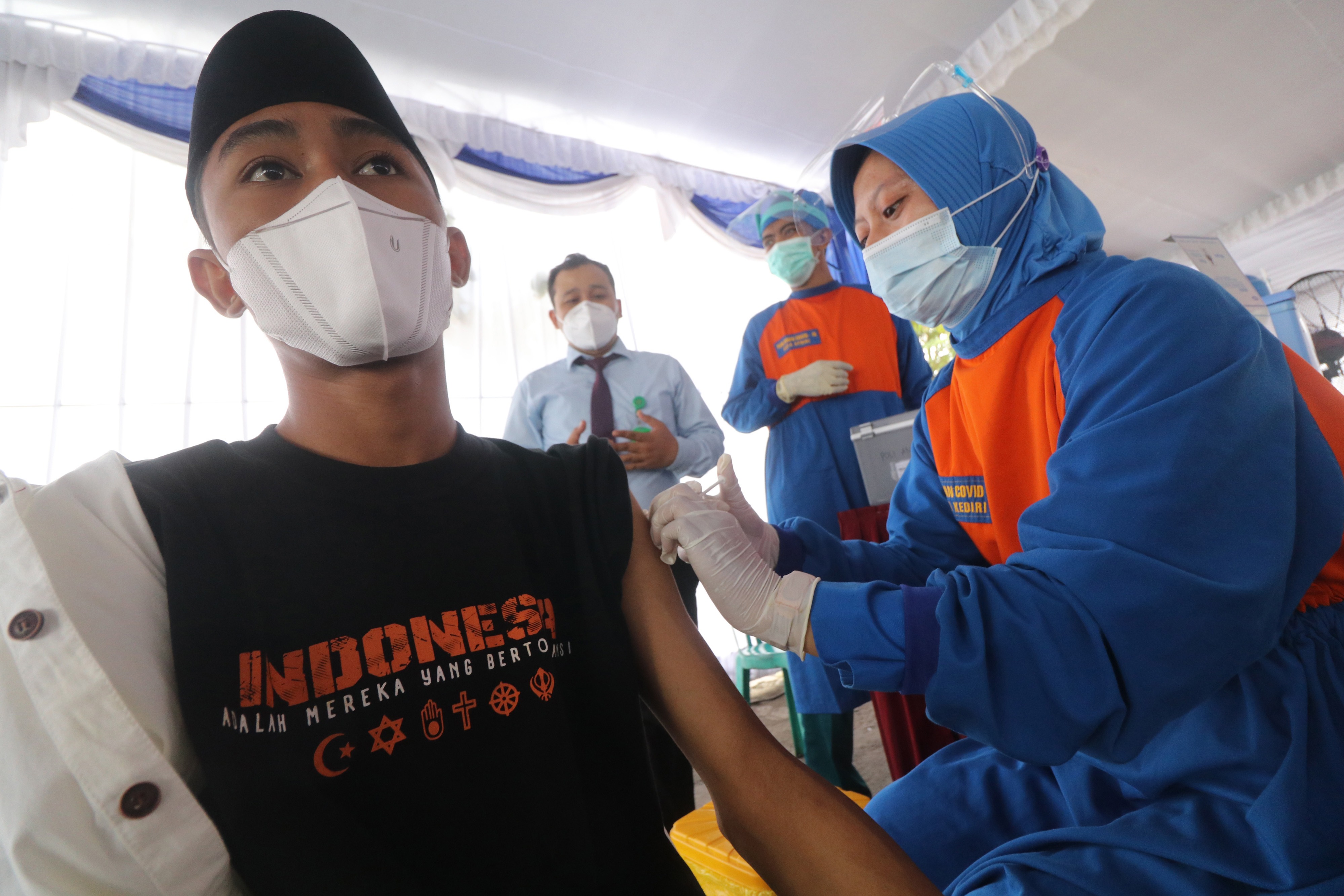 Petugas kesehatan menyuntikkan vaksin covid-19 AstraZeneca kepada santri di Ponpes Lirboyo, Kota Kediri, Jawa Timur, Selasa (23/3).