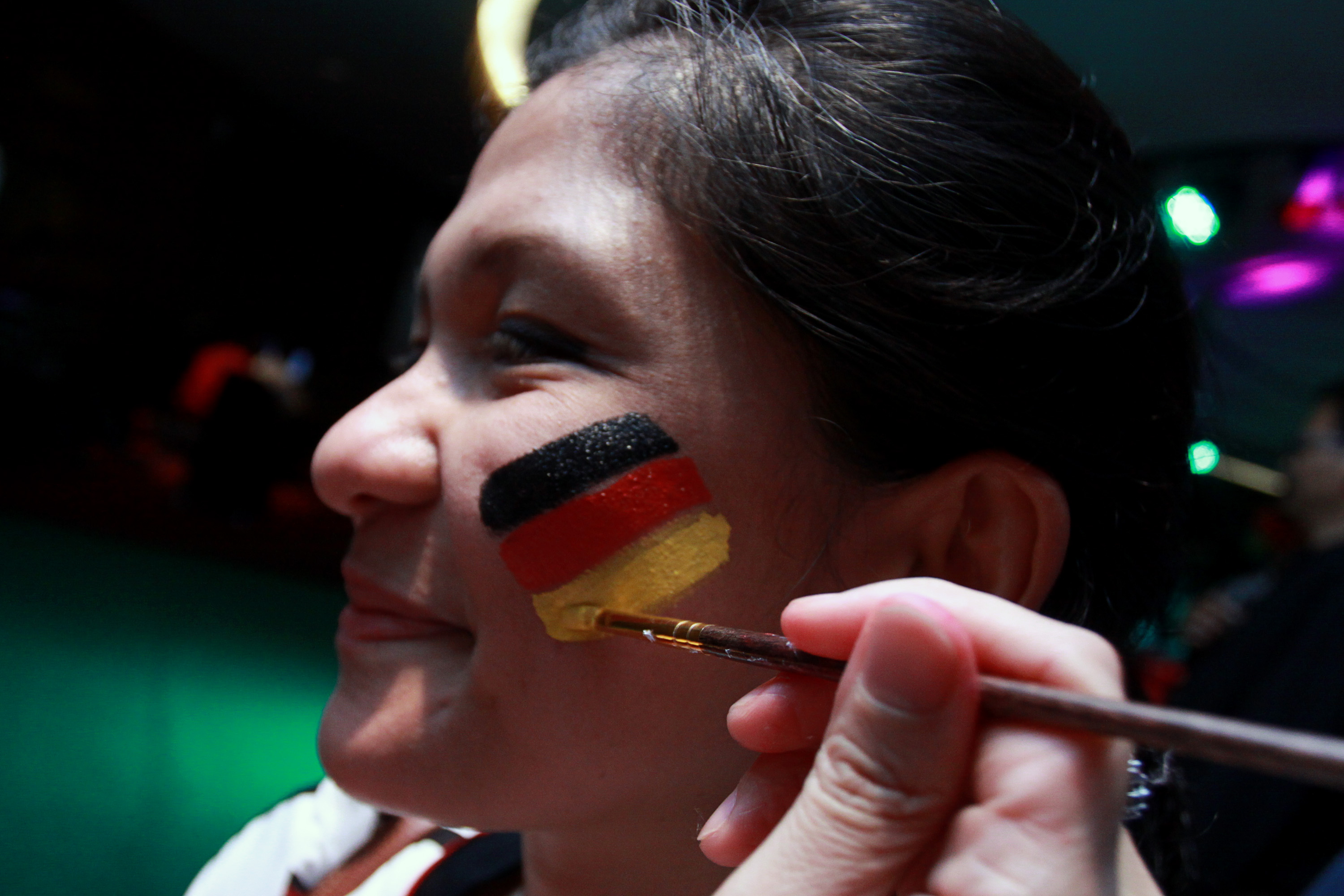 Pendukung Tim Jerman melukis bendera Jerman di pipinya.