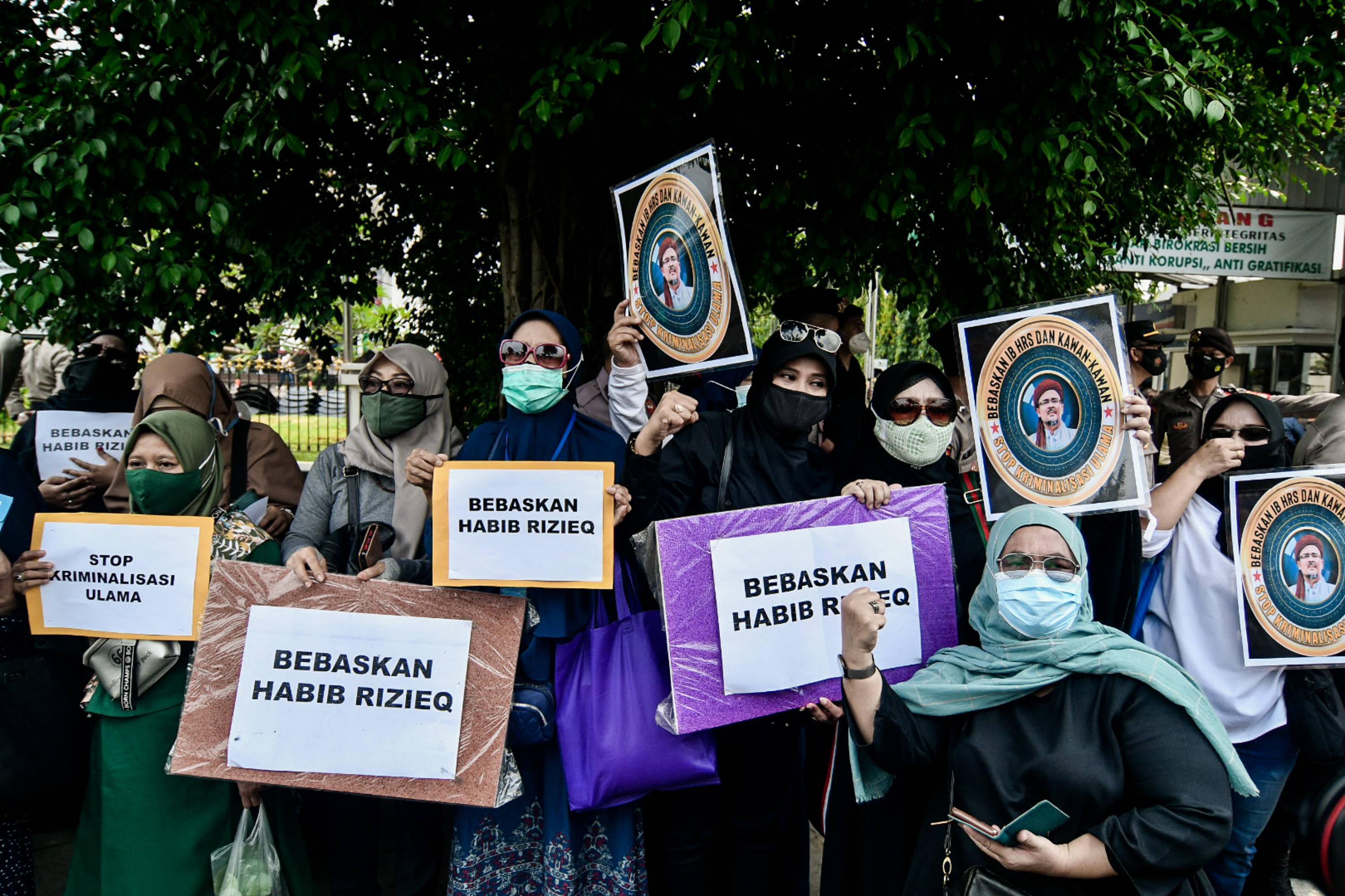  Massa pendukung berkumpul saat berlangsungnya sidang perdana kasus pelanggaran protokol kesehatan dengan terdakwa Rizieq Shihab