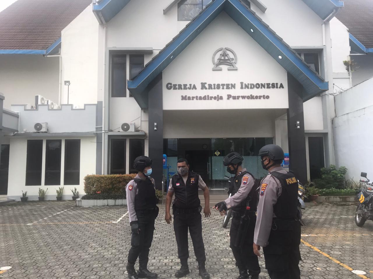 Anggota Polresta Banyumas, Jawa Tengah melakukan penjagaan di gereja. 