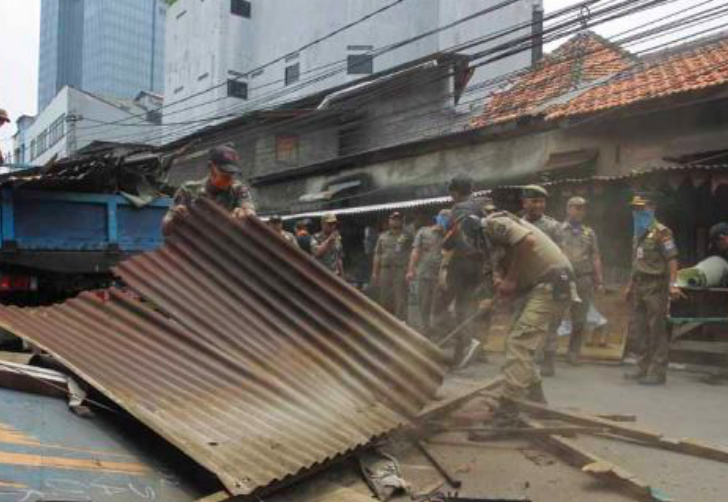 Petugas Satuan Polisi Pamong Praja menertibkan bangunan liar semi permanen yang terdapat di sepanjang Jalan Kebon Sirih Timur Dalam, Jakarta