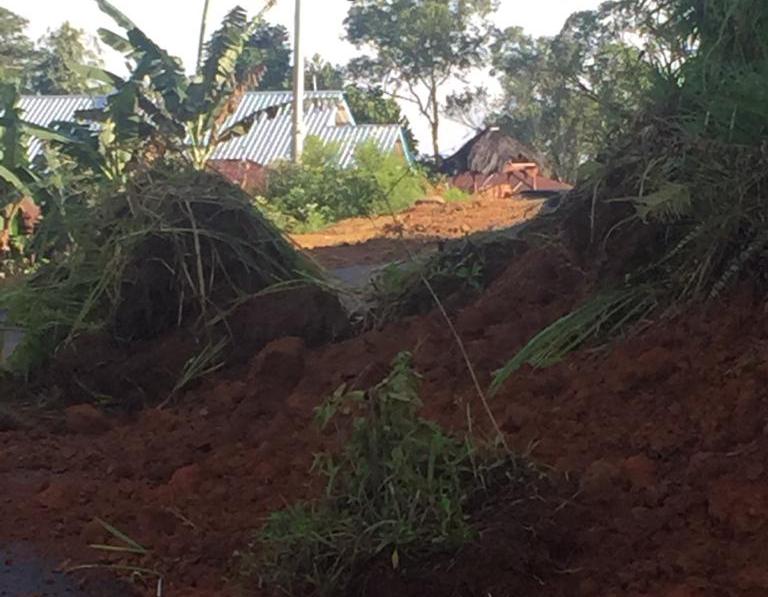 Hujan deras menyebabkan tanah longsor dan menutupi jalan.