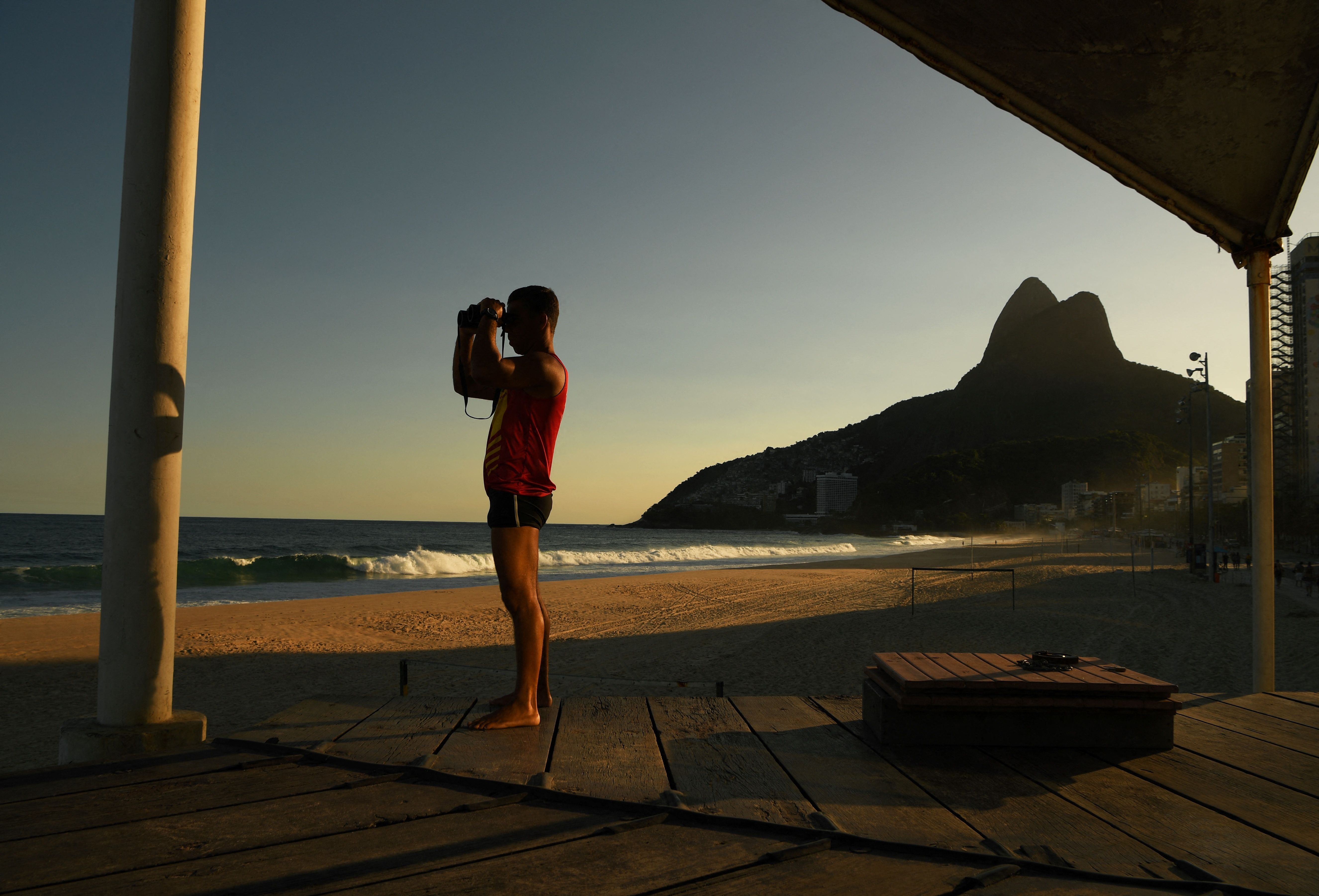 Seorang penjaga pantai mengawasai Pantai Ipanema di Rio de Janeiro yang kosong karena ditutup pemerintah.