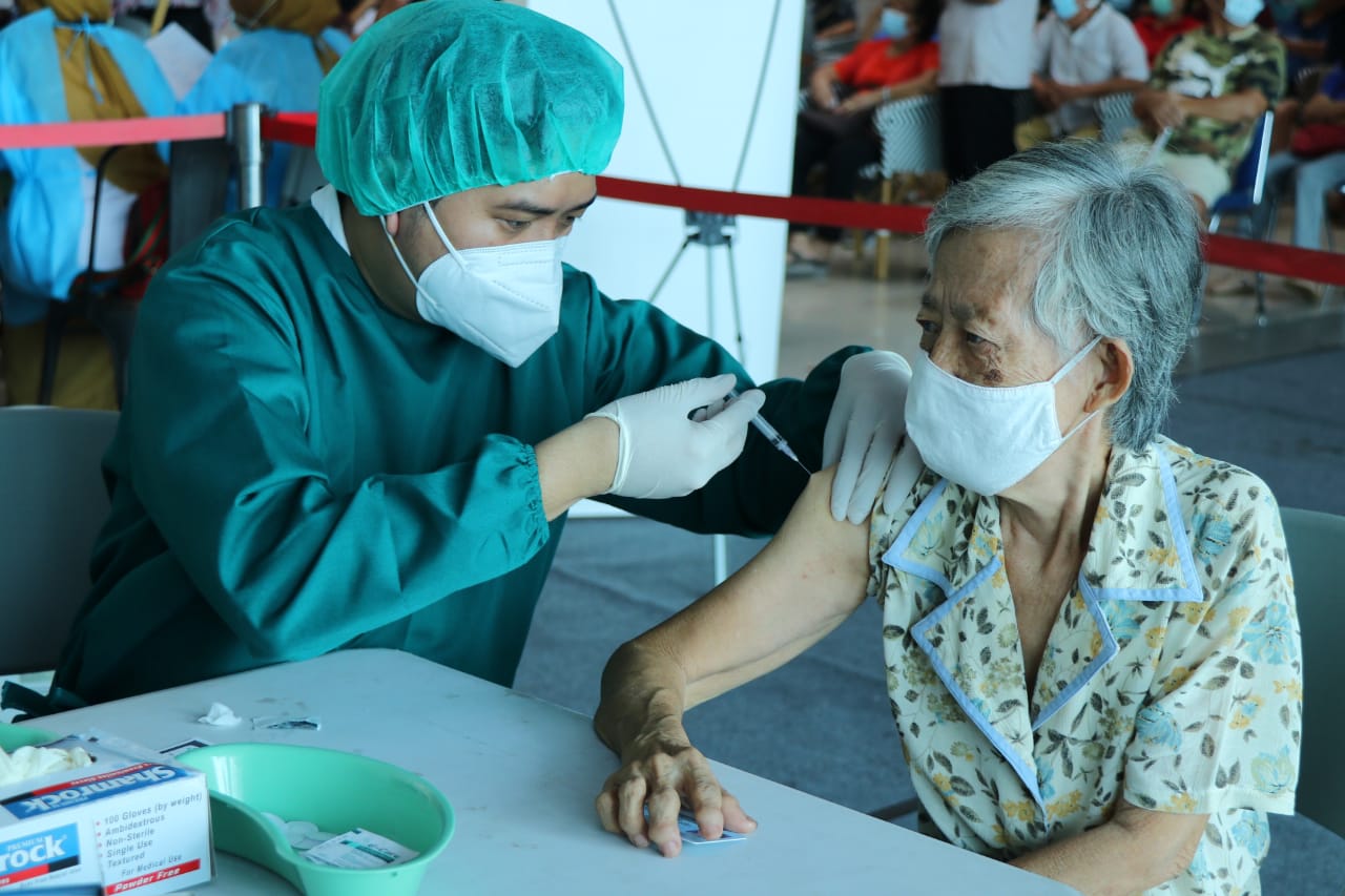 Vaksinasi Lansia: Seorang petugas medis menyuntikan vaksin kepada warga lansia. Berbagai kebijakan dibuat agar semua lansia mudah mendapatka
