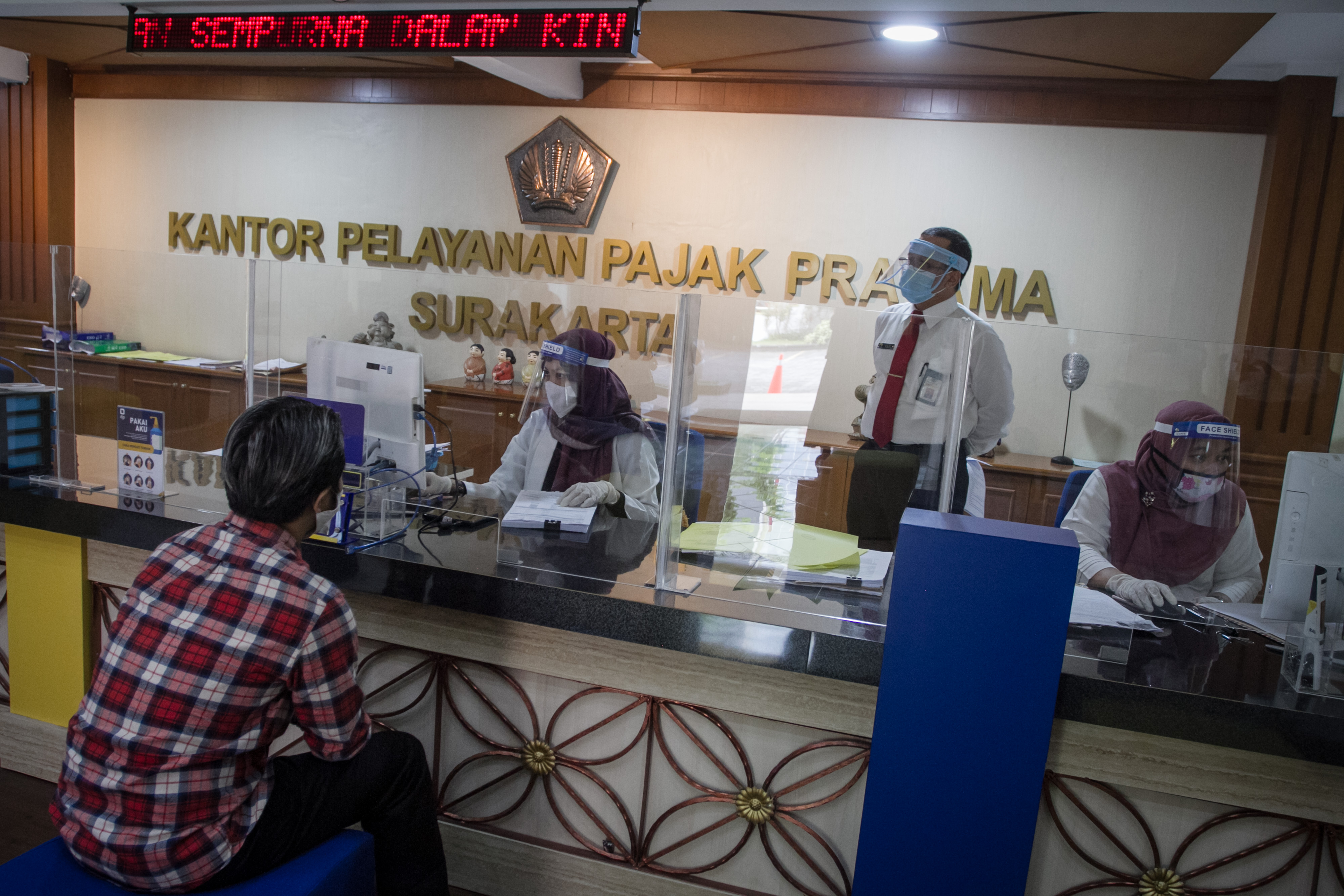 Petugas melayani wajib pajak di kantor pajak