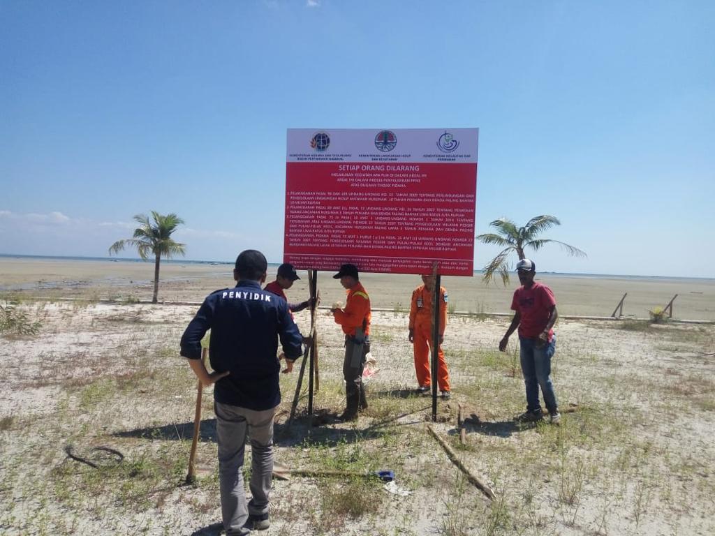 Petugas Gakkum KLHK memasang papan larangan orang masuk ke wilayah Pantai Tanjung Pendam Belitung tanpa izin.