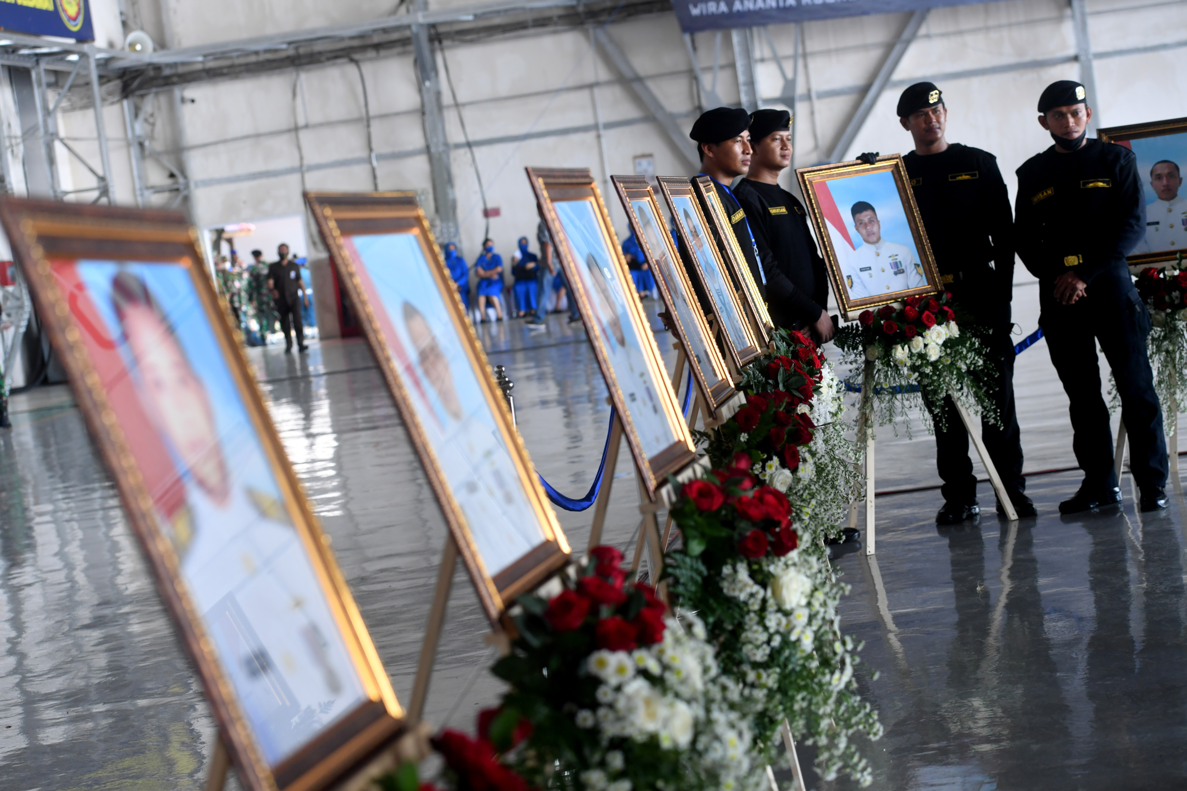 Sejumlah prajurit TNI AL berpose di samping deretan foto prajurit KRI Nanggala-402 yang gugur.