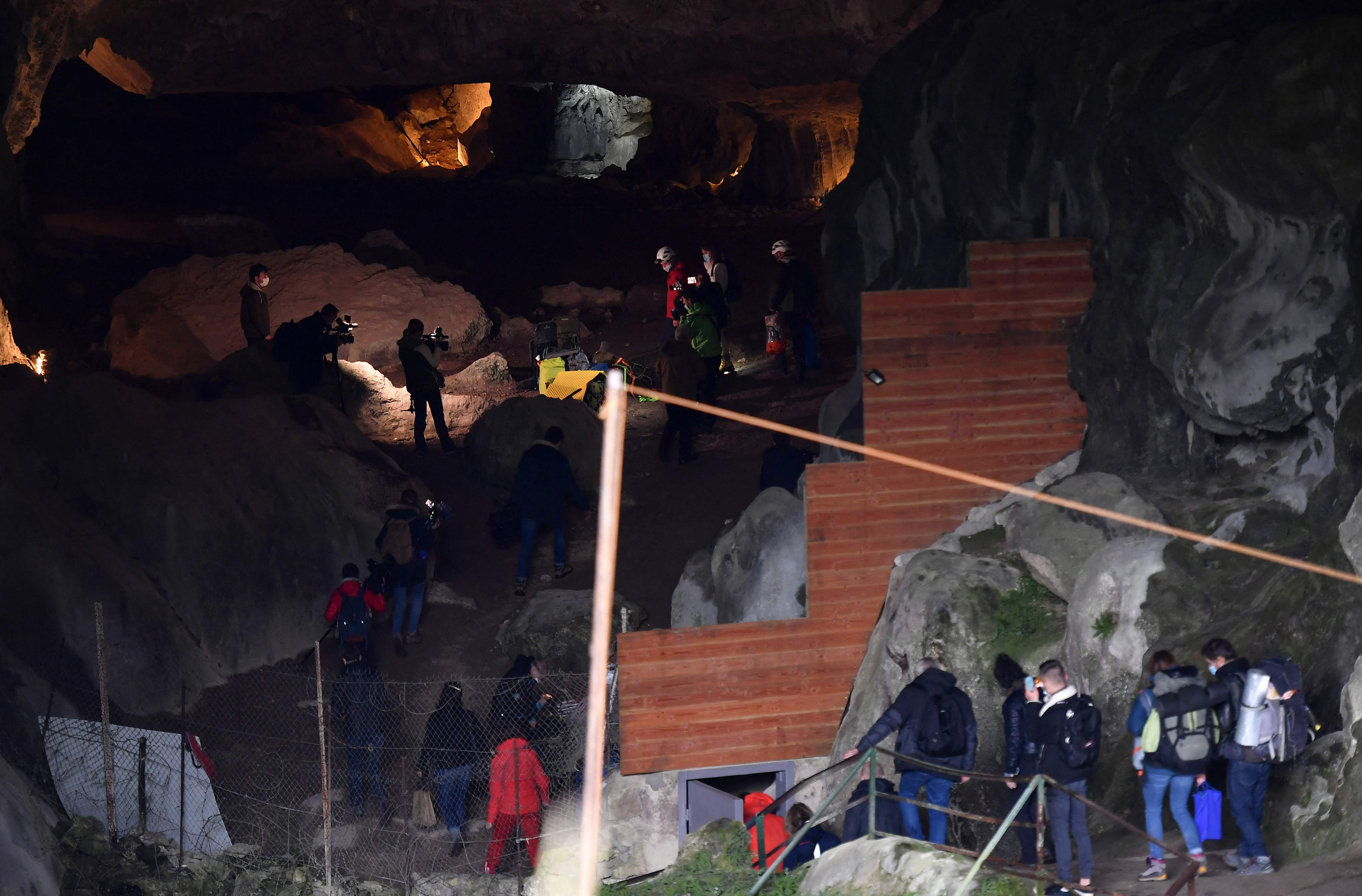 Jurnalis dan anggota proyek penelitian di pintu masuk gua Lombrives di Ussat, Prancis 