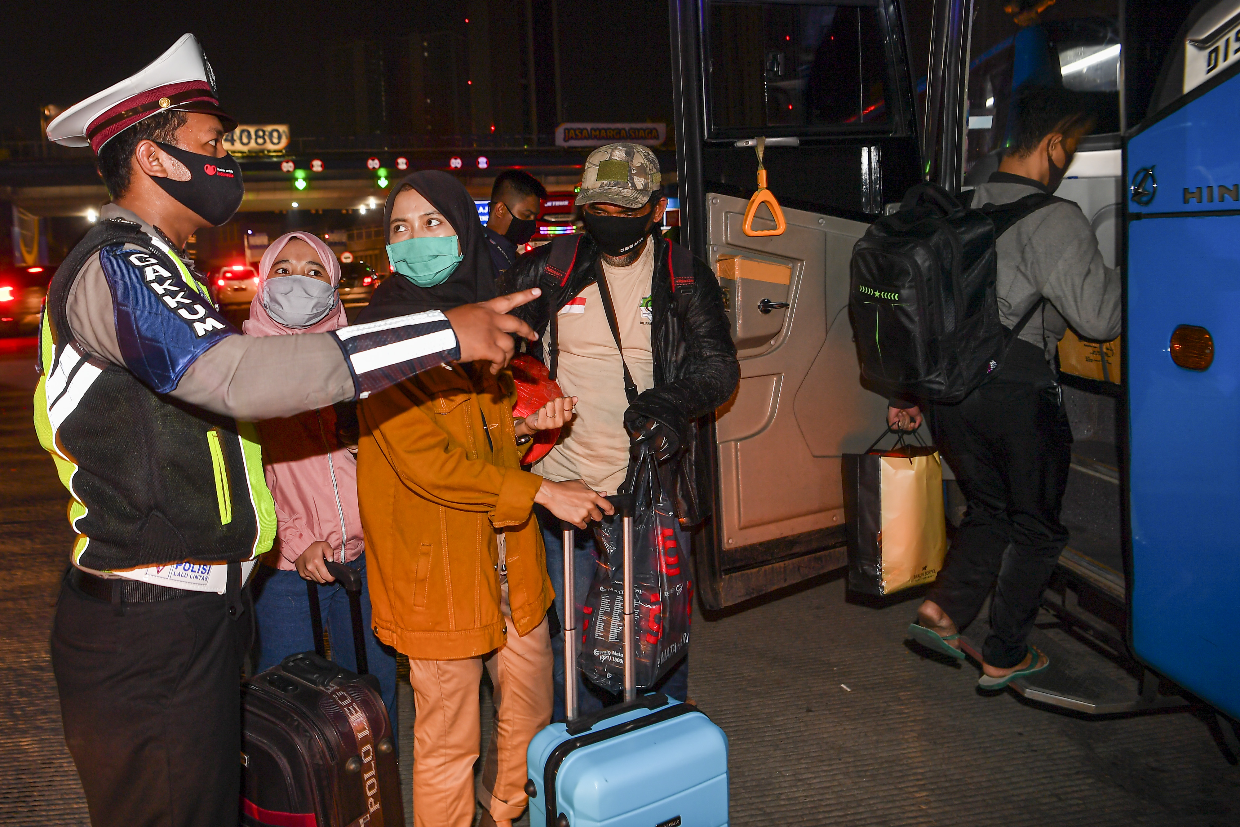 Petugas kepolisian kepolisian mengarahkan pemudik yang terjaring razia larangan mudik di Gerbang Tol Cikarang, Bekasi, tahun lalu.