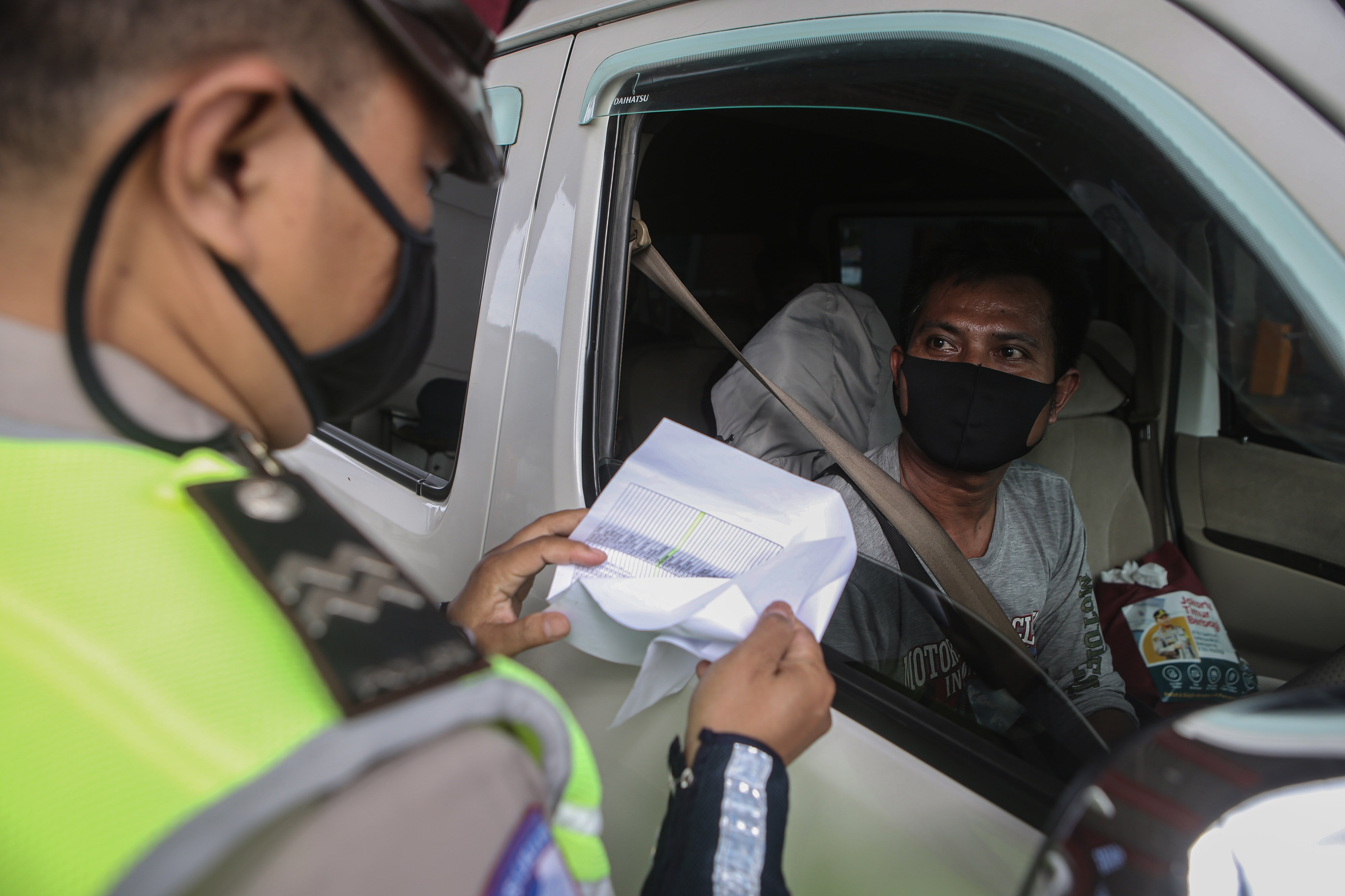 Petugas memeriksa surat-surat penumpang kendaraan yang keluar jakarta saat mudik tahun lalu.