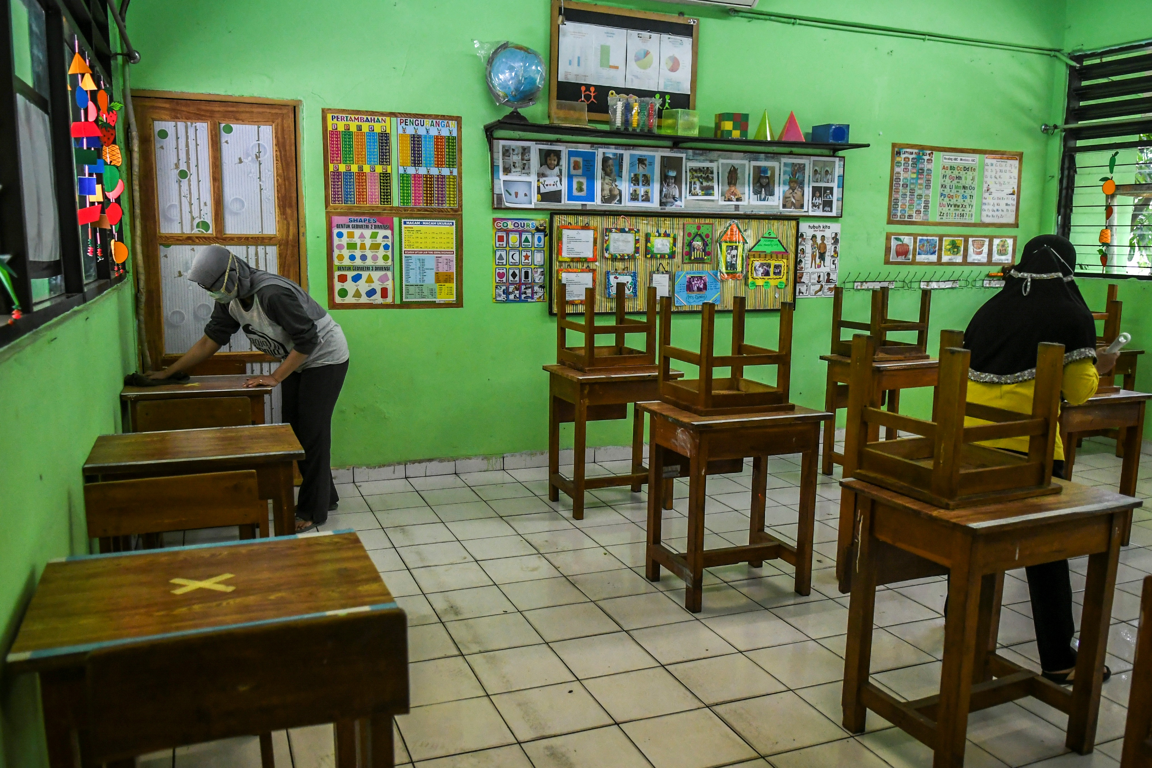 Guru merapikan ruang kelas di SD Kenari 08 Pagi, Jakarta, Selasa (6/4).