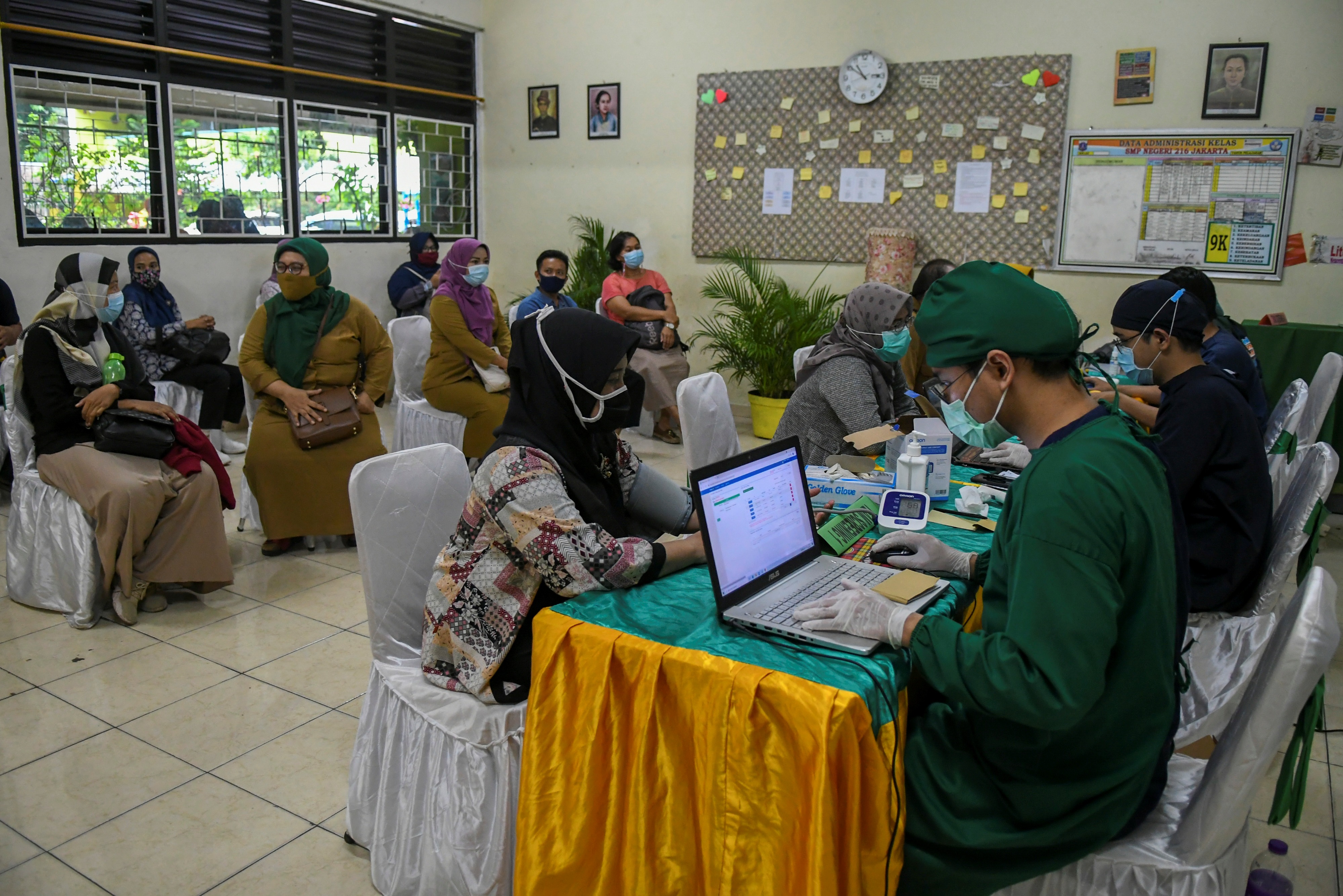 Tenaga kesehatan mendata tenaga pendidik yang akan divaksinasi covid-19 di SMP 216, Jakarta, Selasa (6/4).