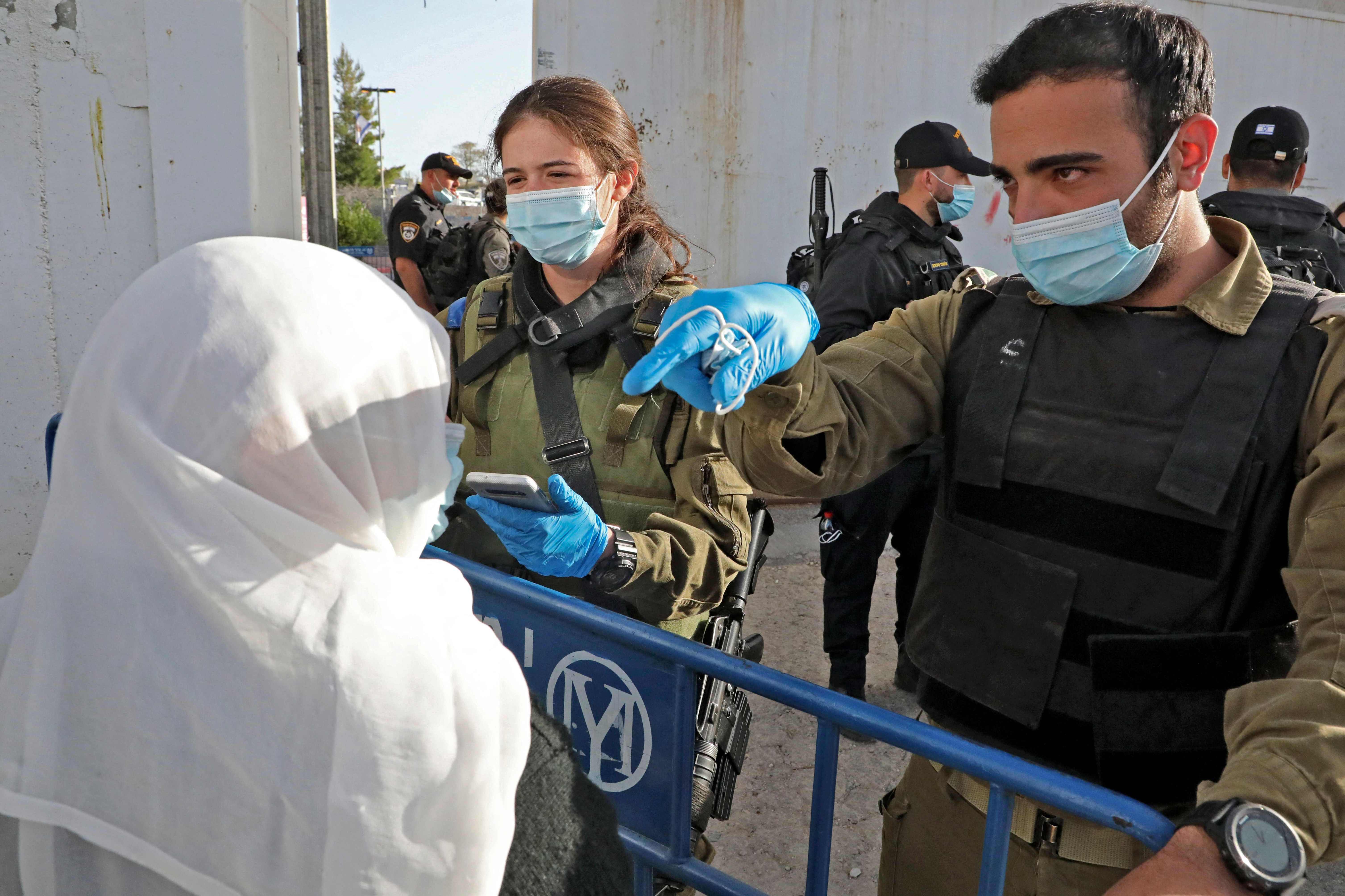 Pasukan keamanan Israel berbicara kepada seorang wanita Palestina ketika ingin menghadiri salat Jumat kedua Ramadan, Jumat (23/4).