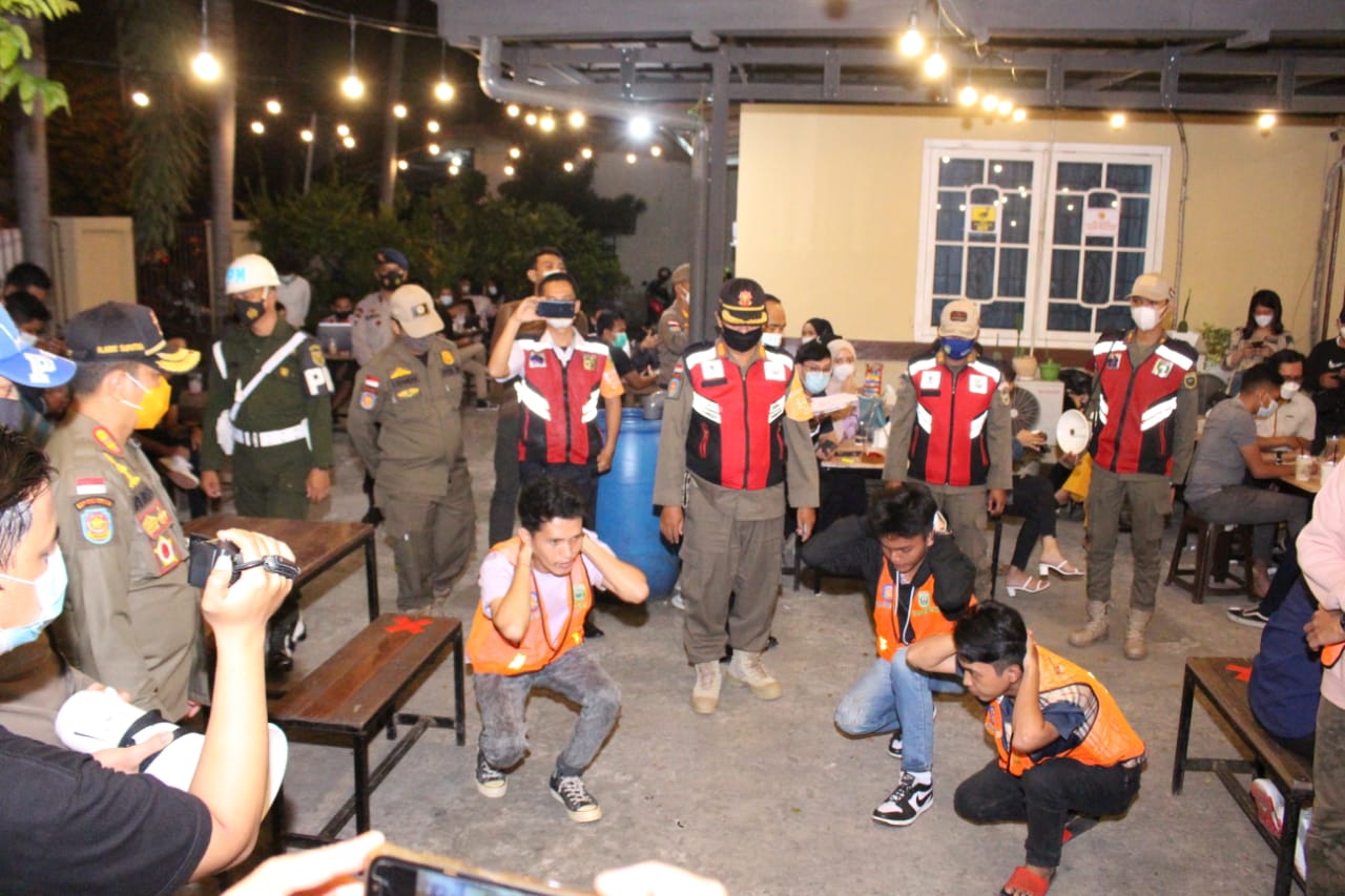 Satpol PP Sumatra Selatan memberi hukuman squat jump untuk pelanggar protokol kesehatan di kafe Kota Palembang, Rabu (28/4/2021)