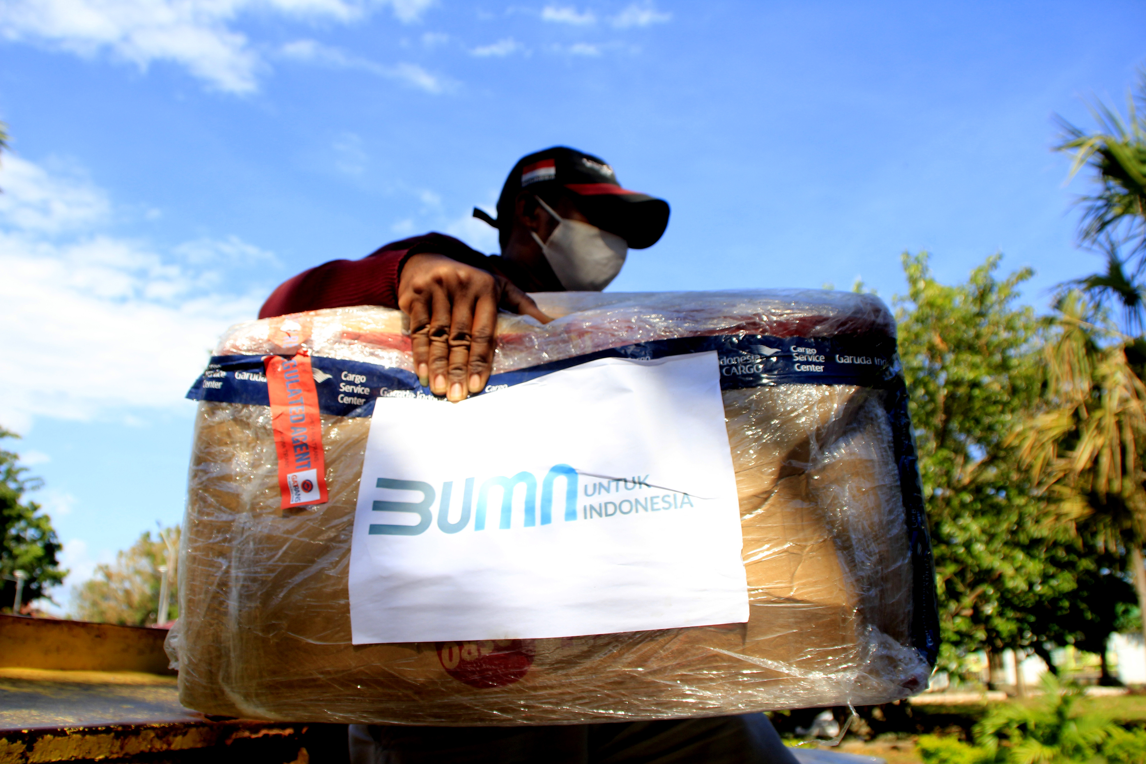 Seorang pria menggendong satu dus bantuan bagi korban bencan alam siklon tropis seroja NTT di Kota Kupang, NTT, Minggu (11/4/2021)