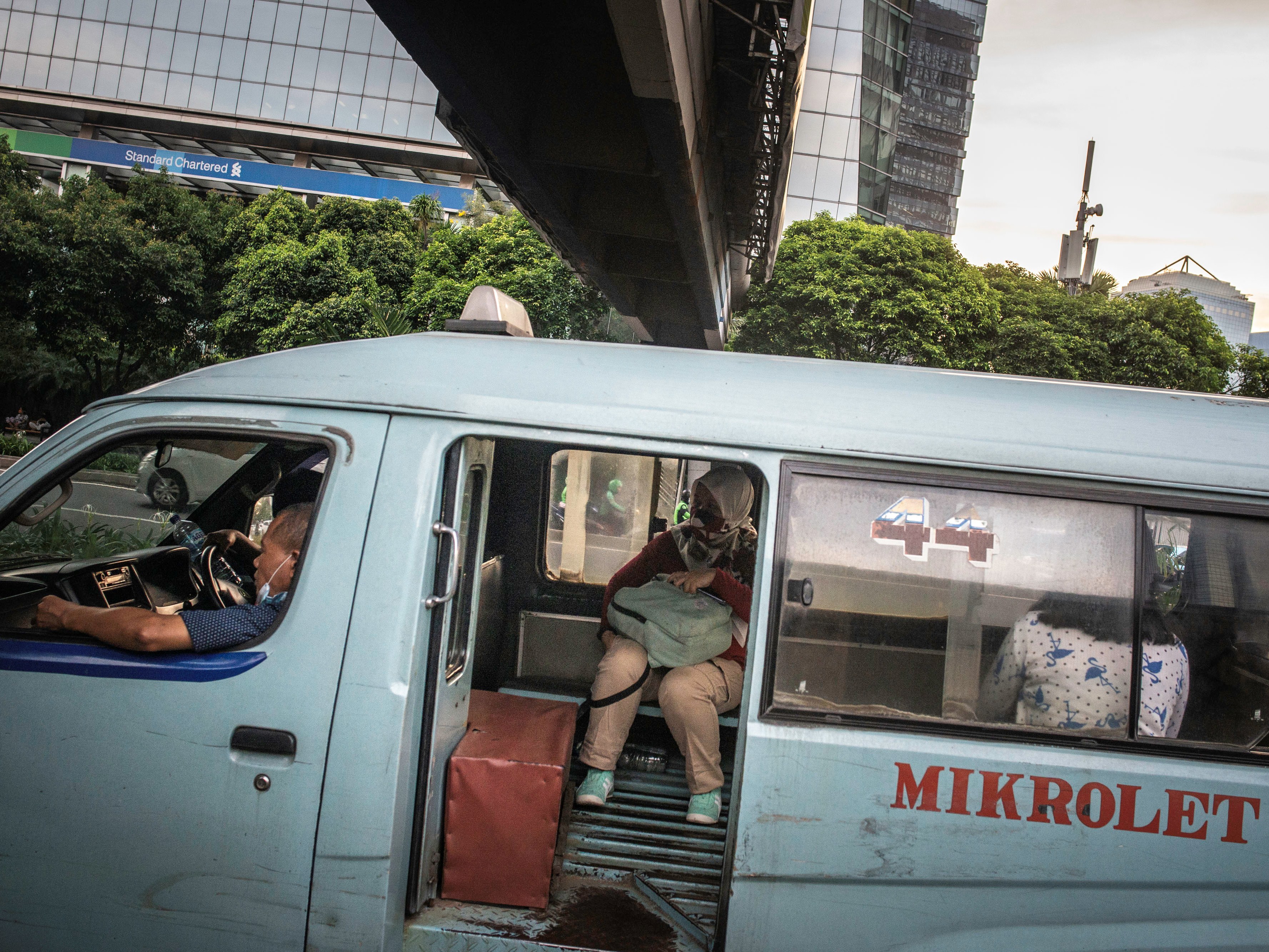 Penumpang duduk di angkutan kota Mikrolet di kawasan Karet Kuningan, Jakarta.